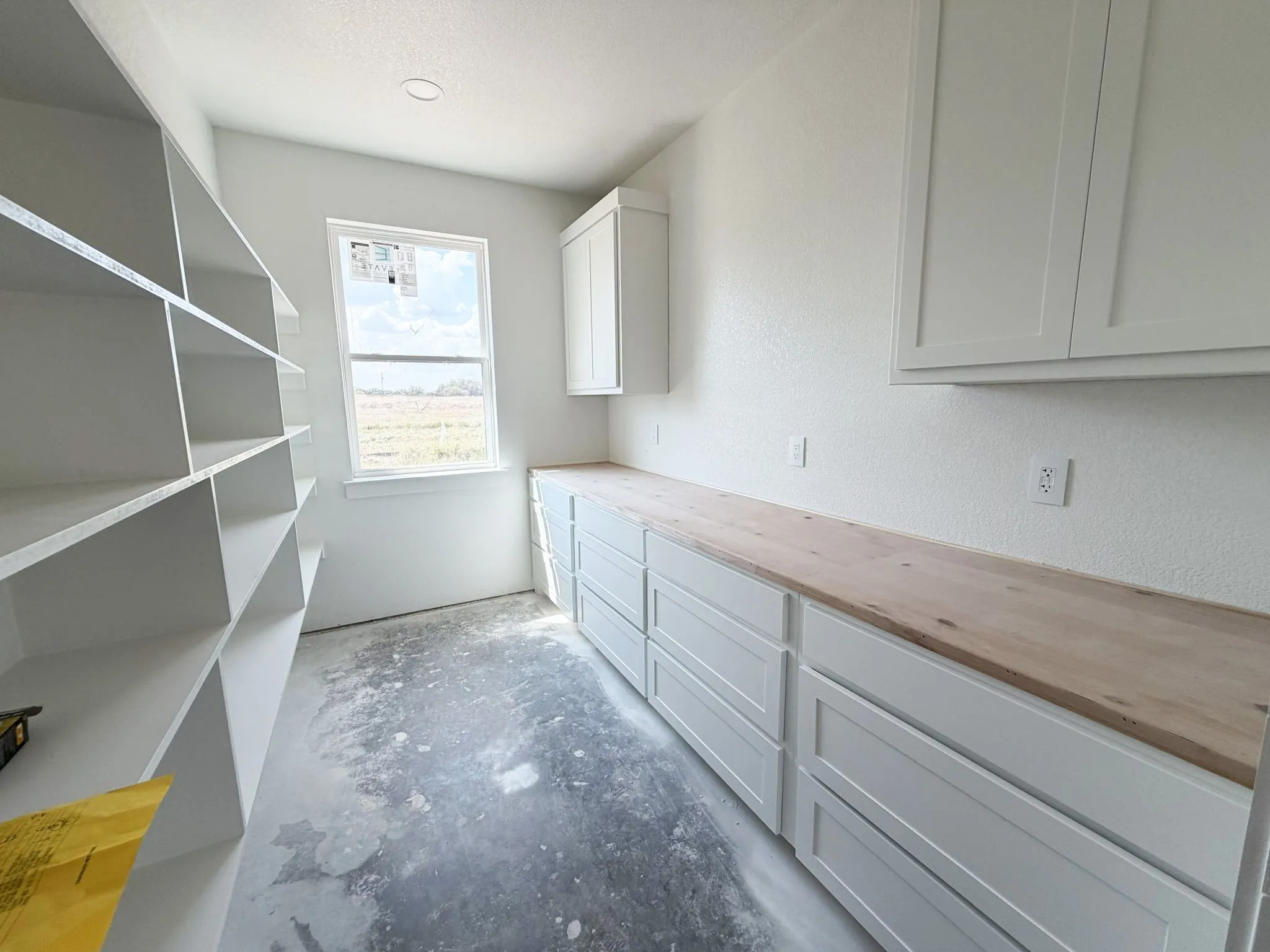 Built-in shelving, white cabinetry, wood-finish countertop, and recessed ceiling lighting