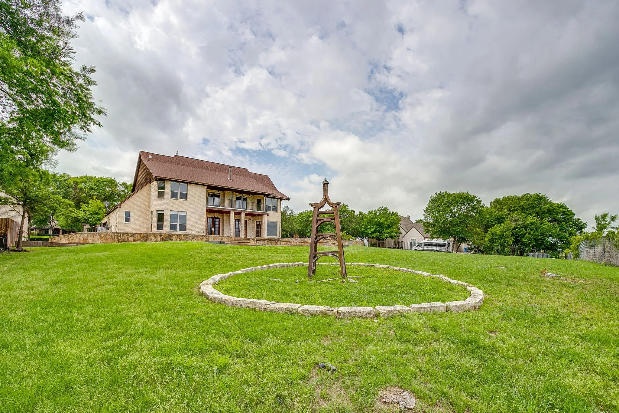 The property features an expansive green lawn and a two-story exterior with a balcony