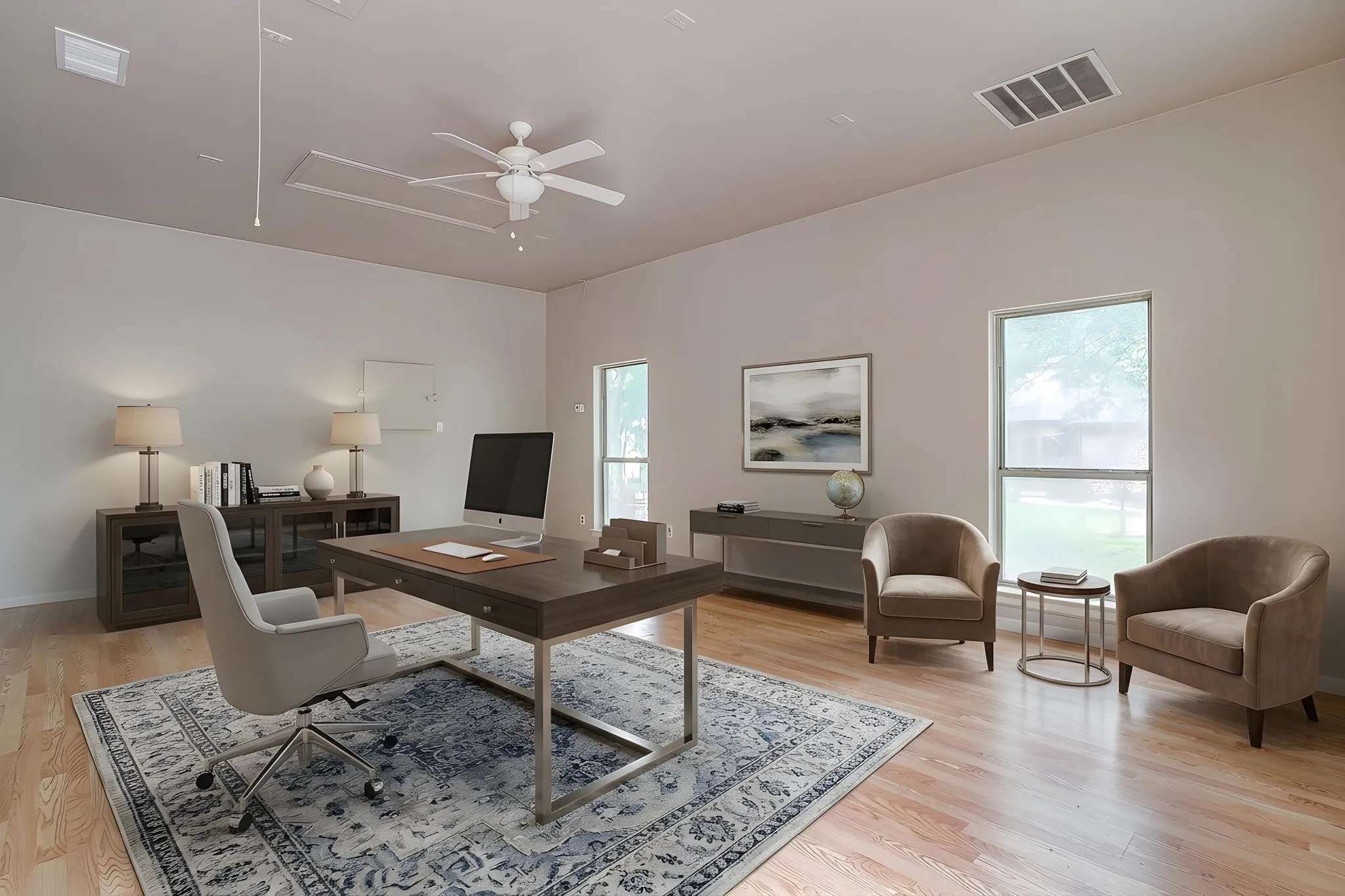 Spacious room featuring light-toned walls, hardwood floors, and a ceiling fan