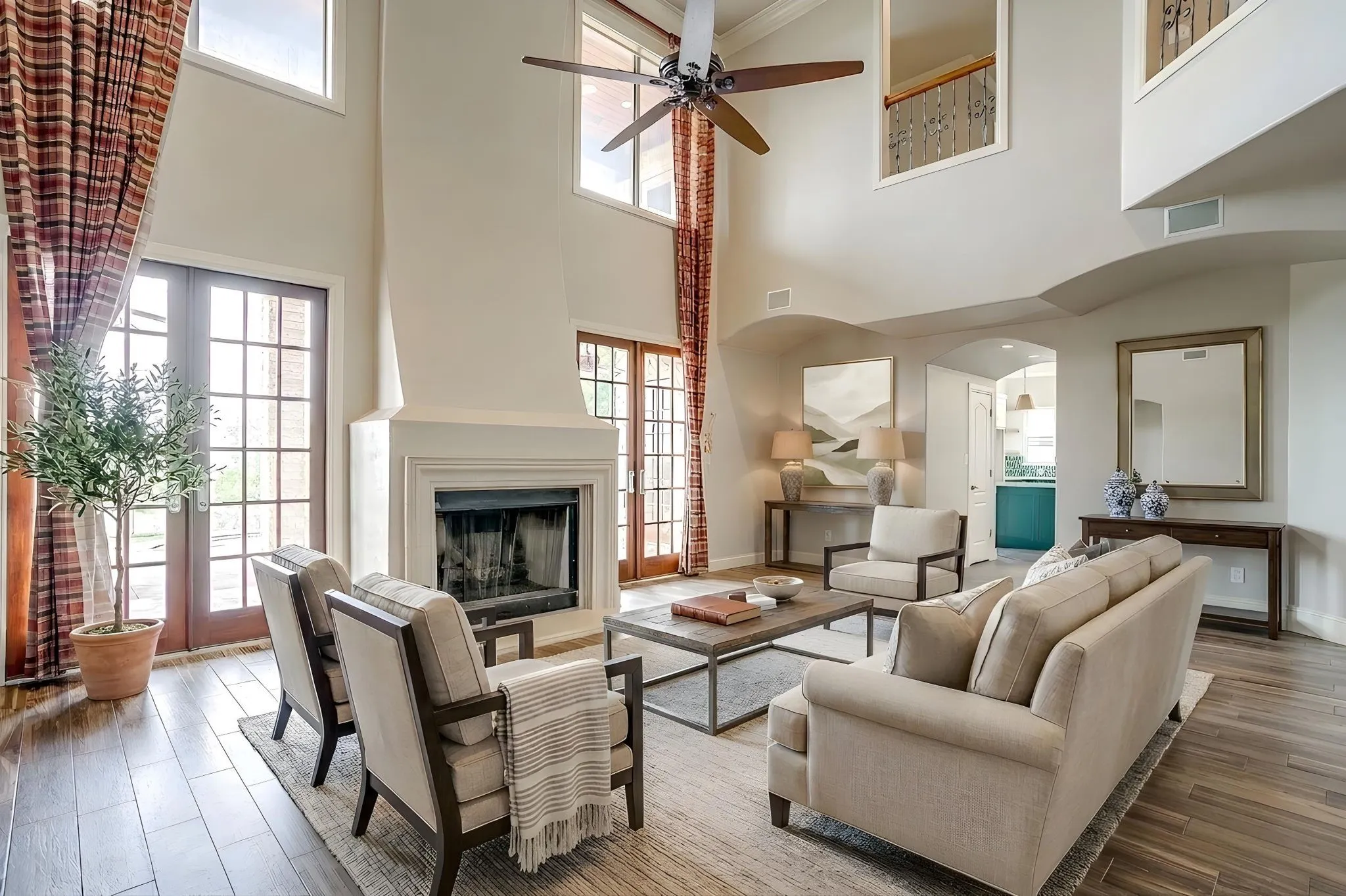 The property features a spacious living area with high ceilings, a fireplace, and hardwood floors
