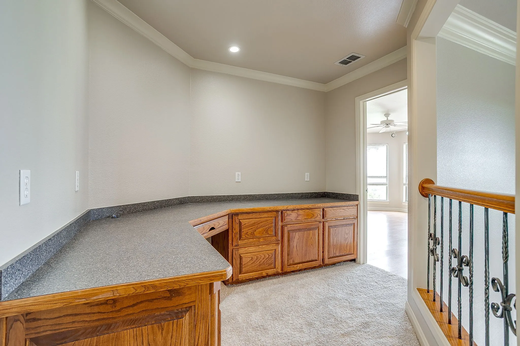This property features a built-in desk with wood cabinetry and a speckled countertop, offering a dedicated workspace
