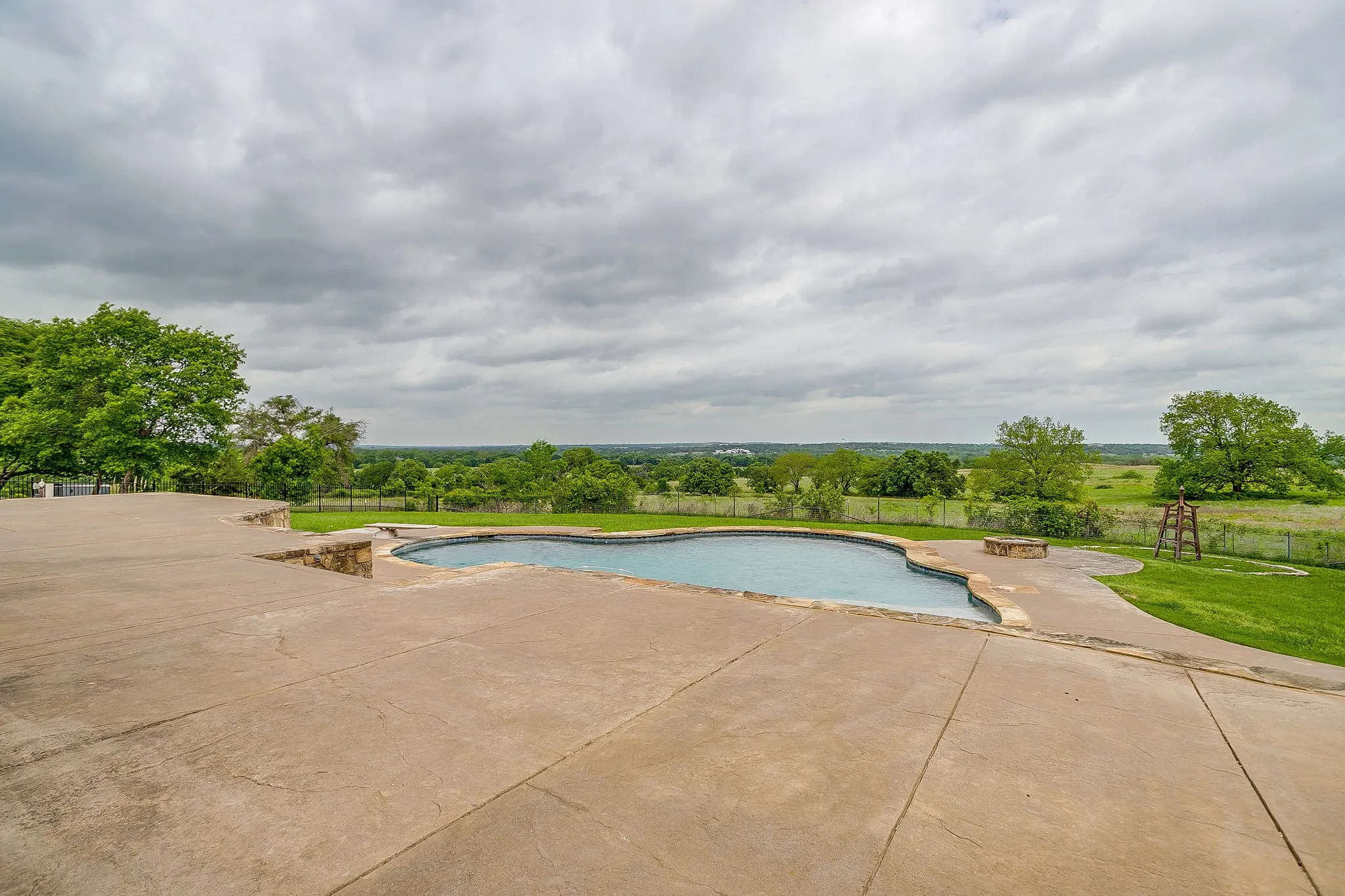 The property features an inviting swimming pool with a concrete patio surround