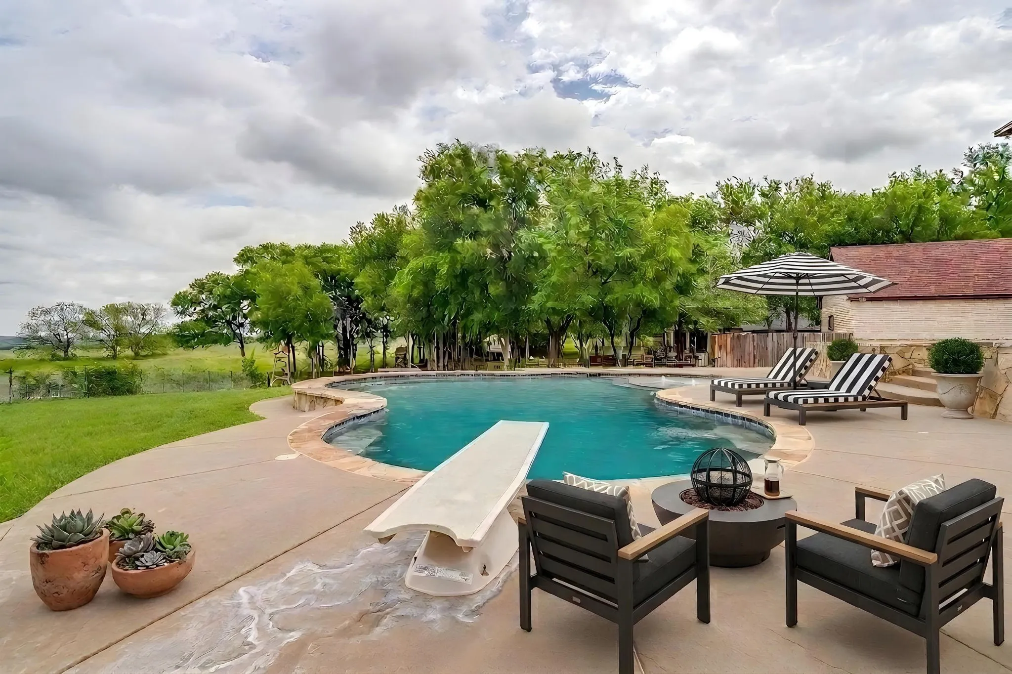 The property features a swimming pool with a diving board, surrounded by a concrete patio