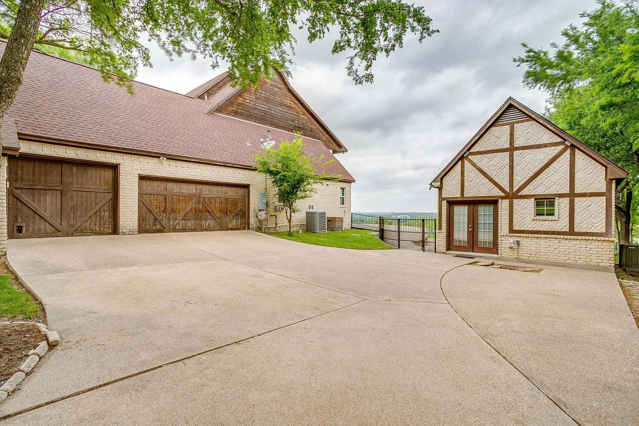 The property features a concrete driveway leading to two distinct structures