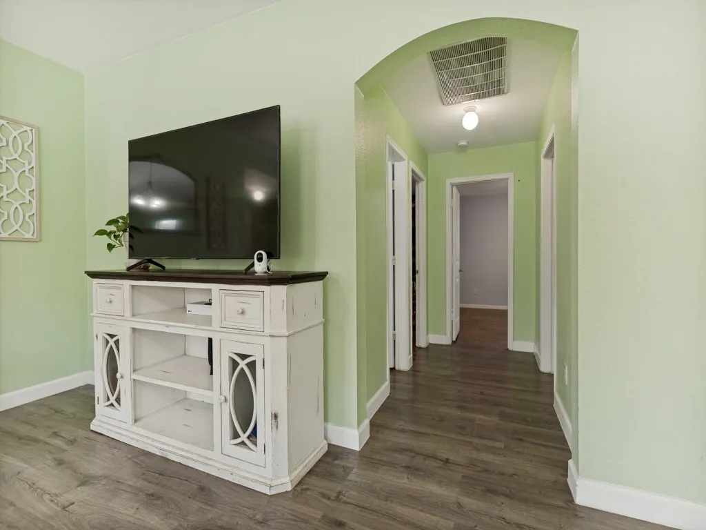 Archway entry to a hallway leading to two bedrooms, the laundry & hall bath.