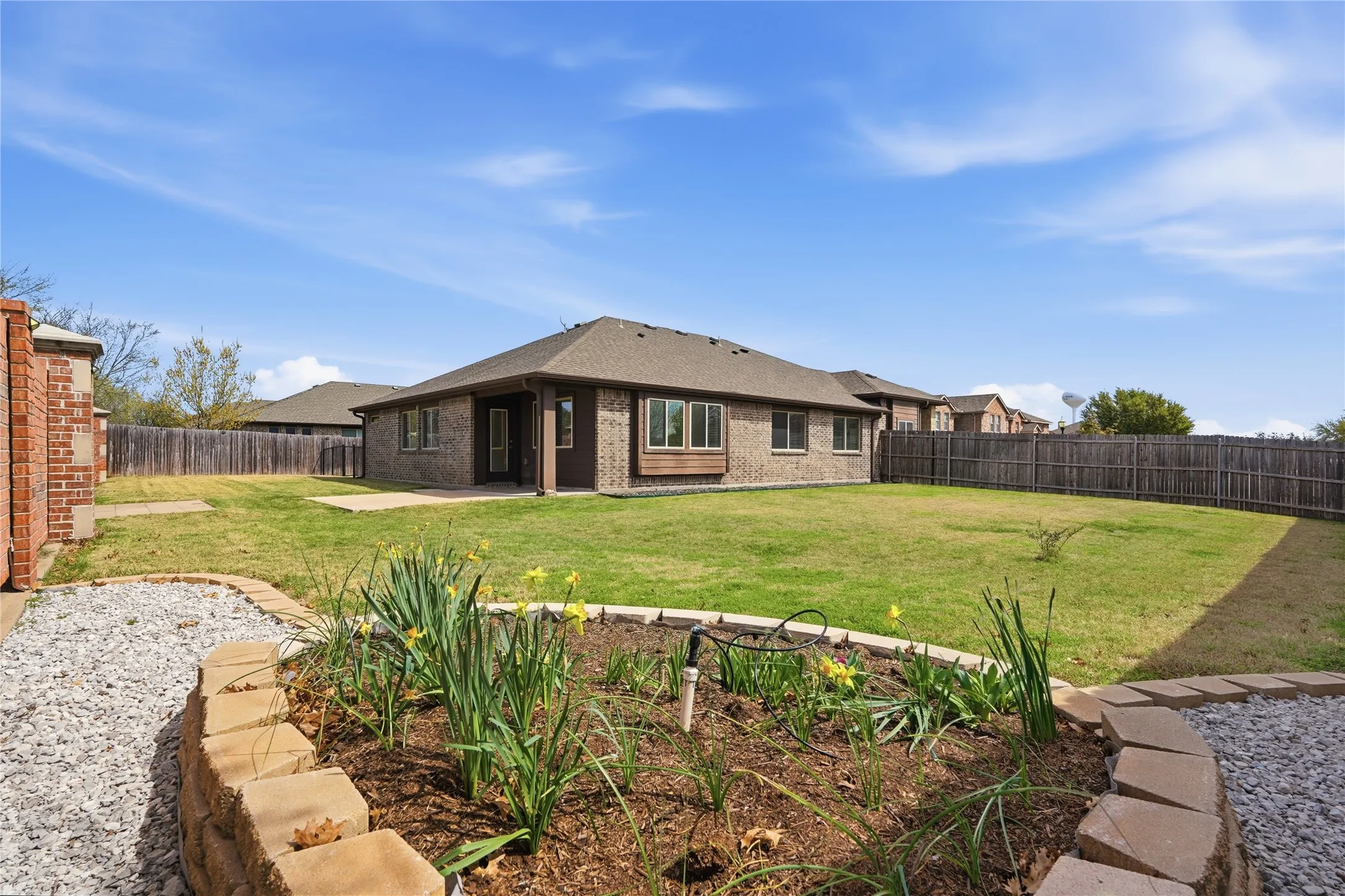 Brick fence maintained by HOA gives backyard character.