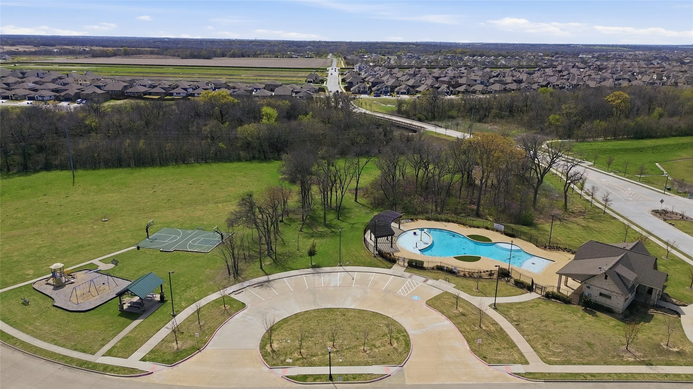 Park with green space includes basketballcourt and playground with covered picnic area.