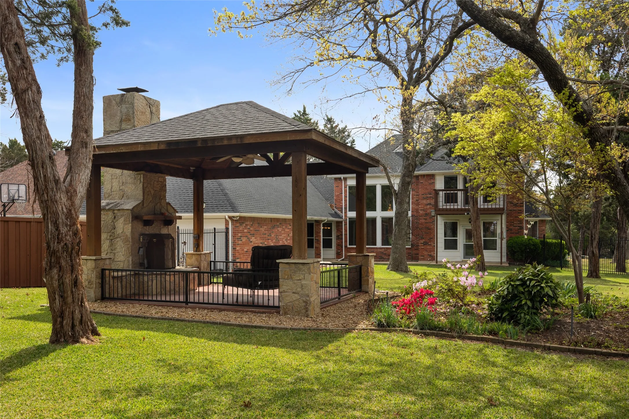 Back of house featuring expansive back yard, a large covered patio, a chimney, and garden area.