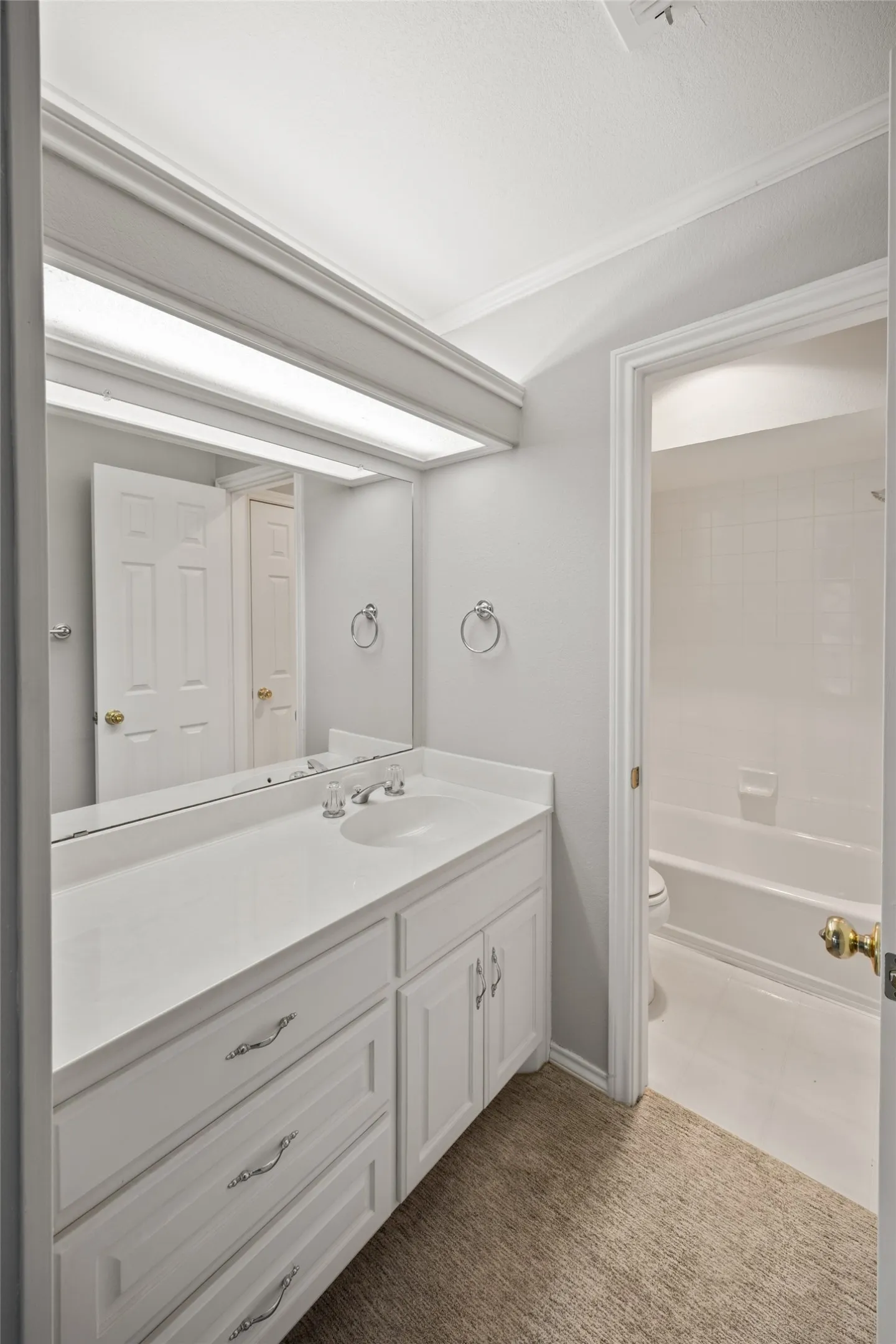 Full bathroom with vanity, crown molding, bathing tub / shower combination, and dark carpet