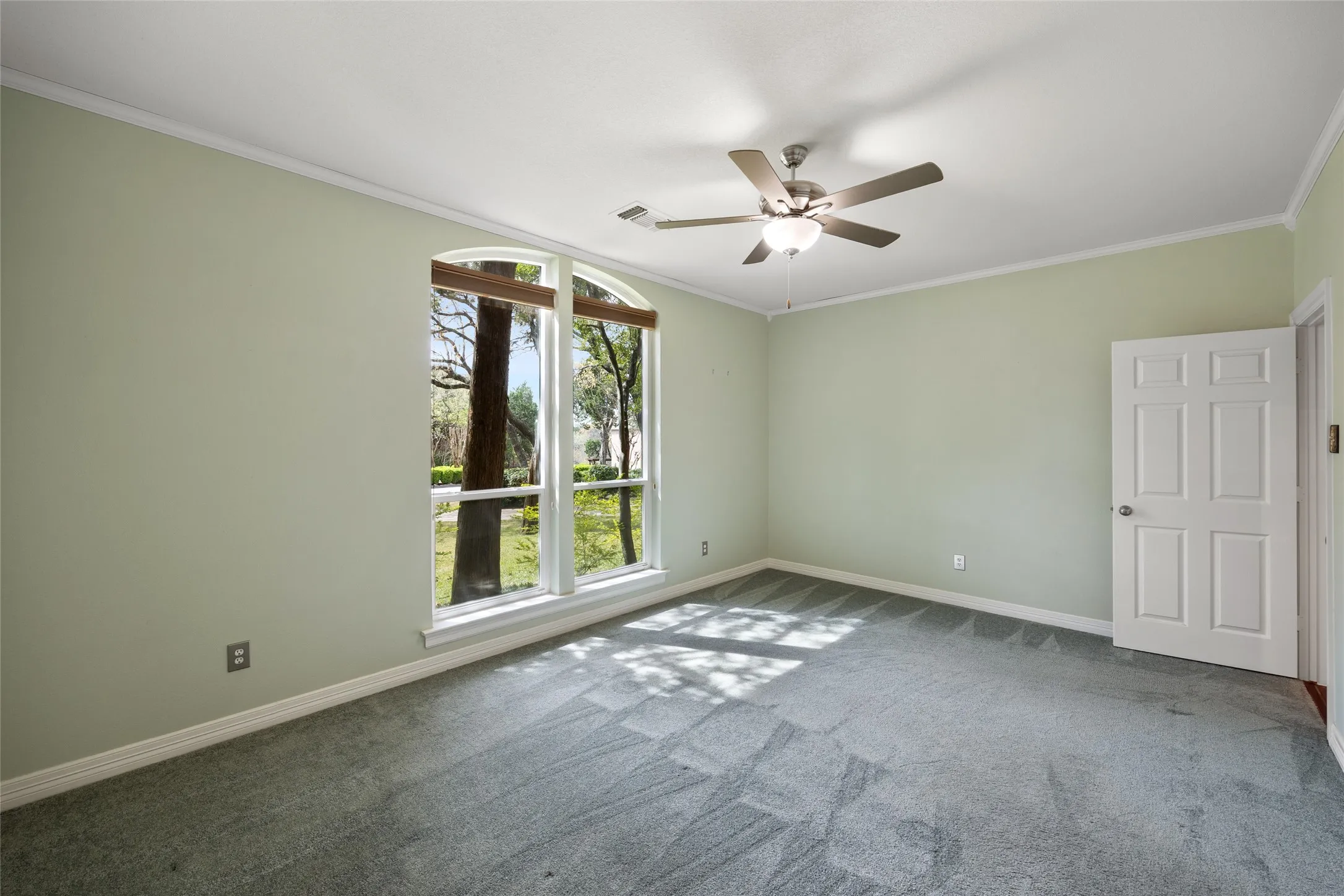 Carpeted empty room with crown molding and ceiling fan