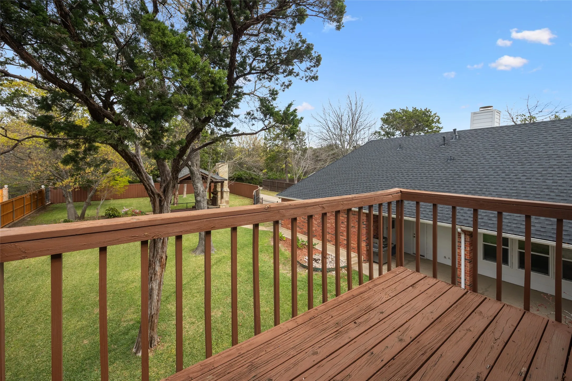 Wooden deck with a fenced backyard