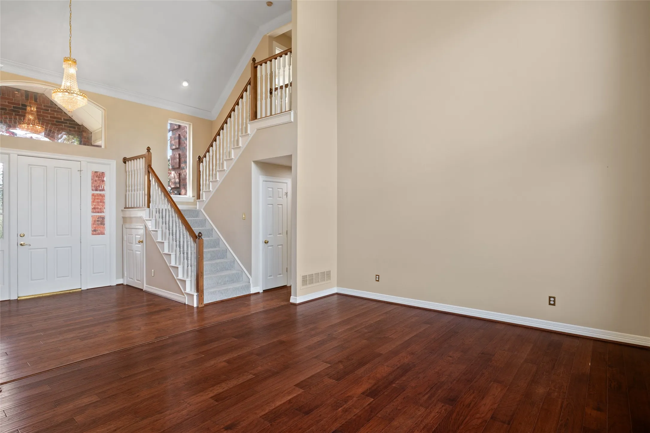Entrance foyer featuring dark wood finished floors, vaulted ceiling, and crown molding, lots of natural light.