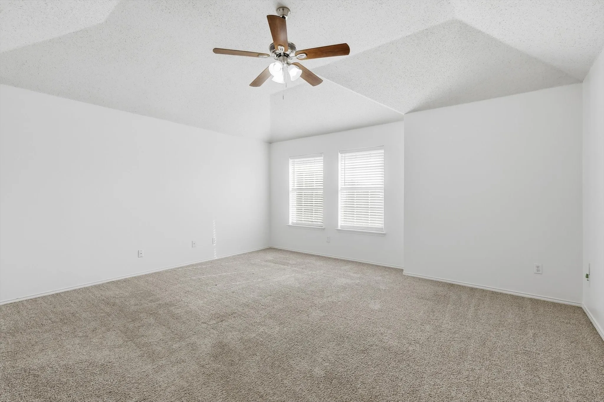 Empty room with carpet floors and ceiling fan