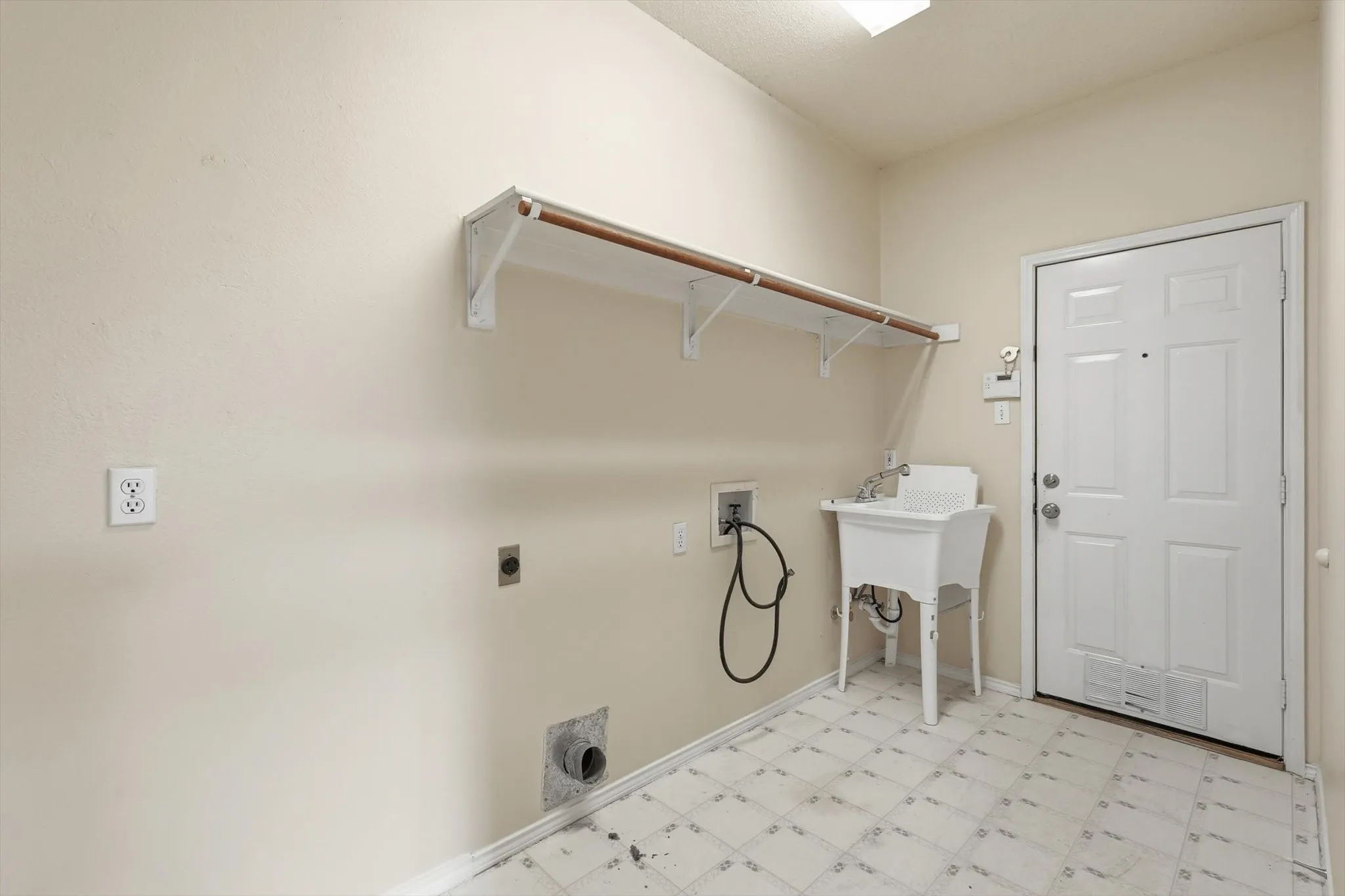 Laundry room with light flooring, hookup for an electric dryer, and washer hookup