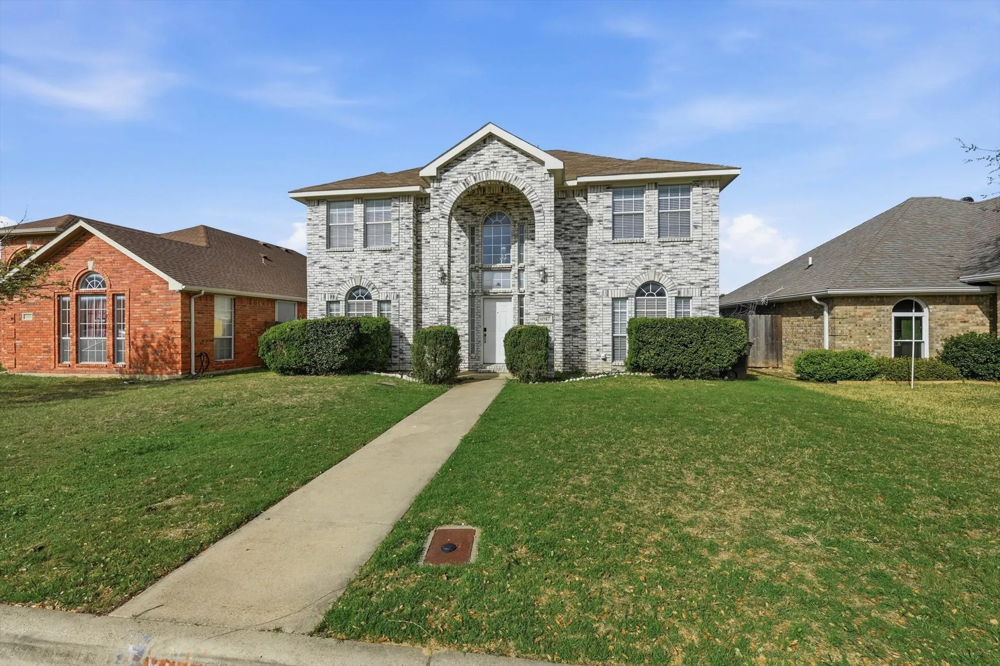 View of front of property featuring a front yard and brick siding