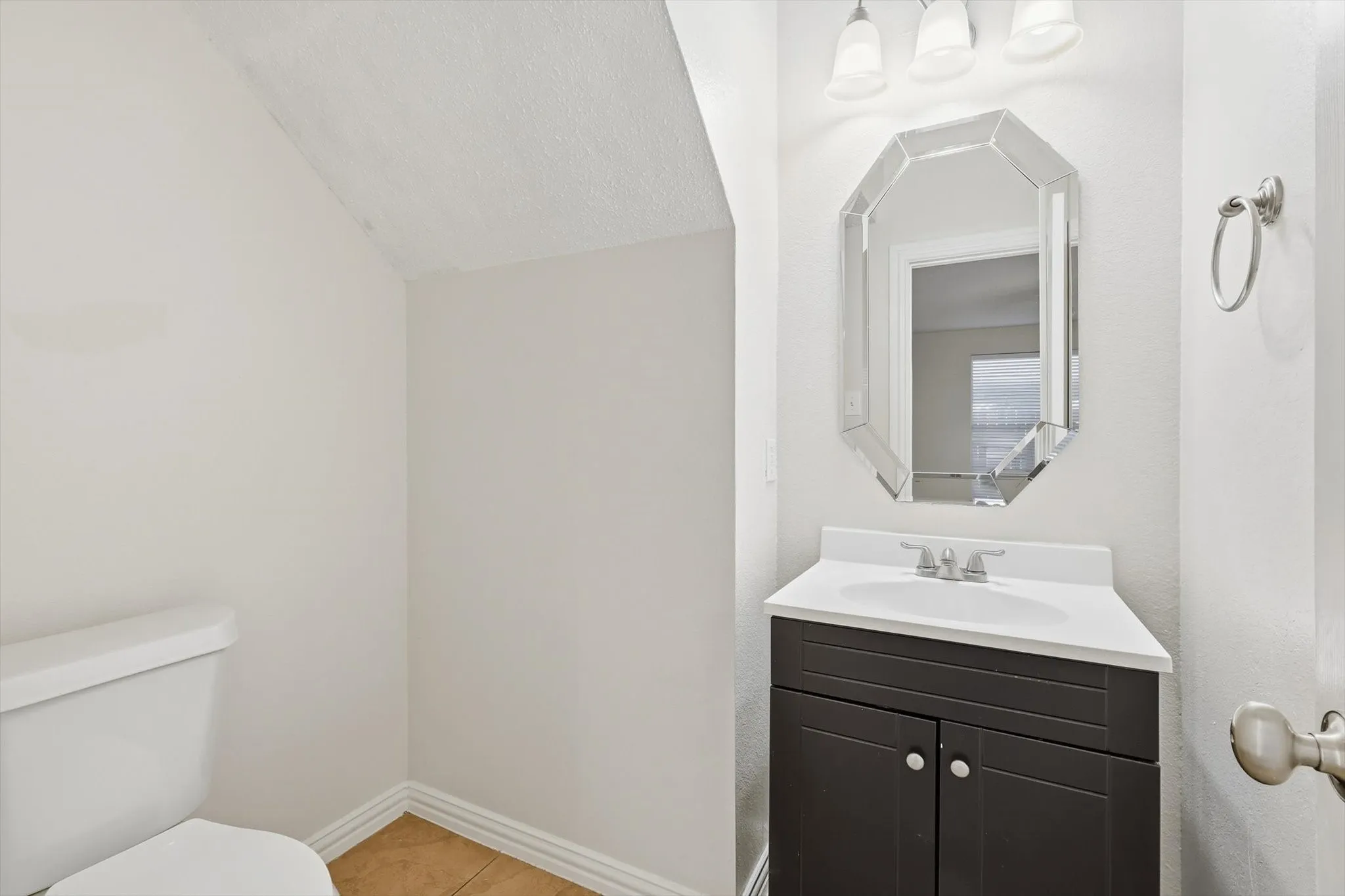 Half bath with vanity and light tile patterned floors