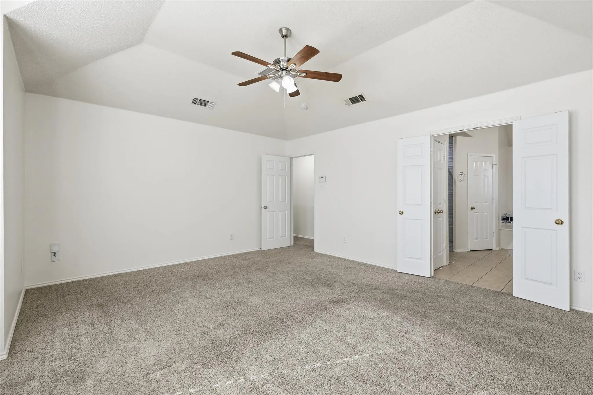 Unfurnished bedroom with light carpet, lofted ceiling, and ceiling fan