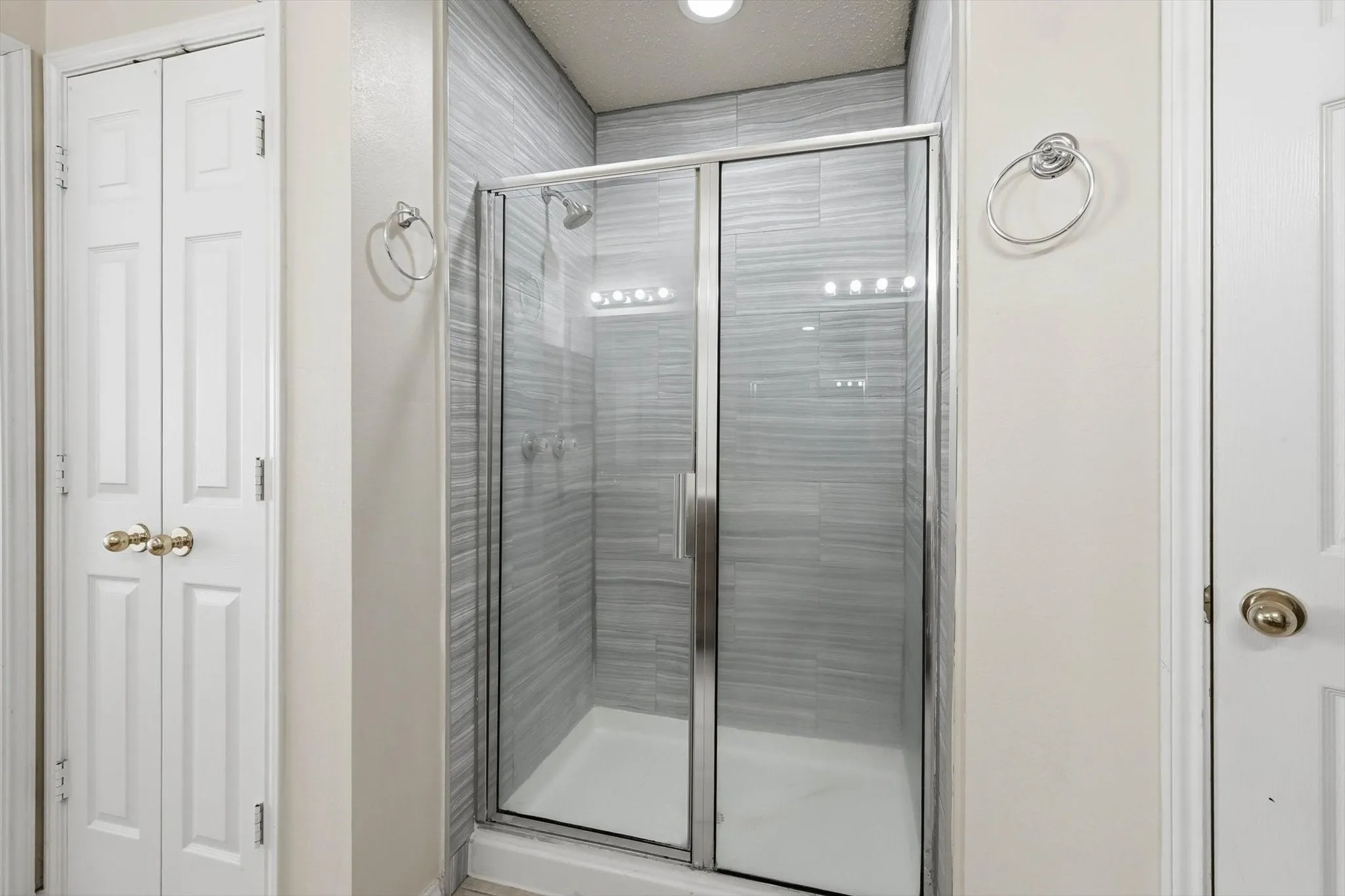 Full bath featuring a shower stall and a closet