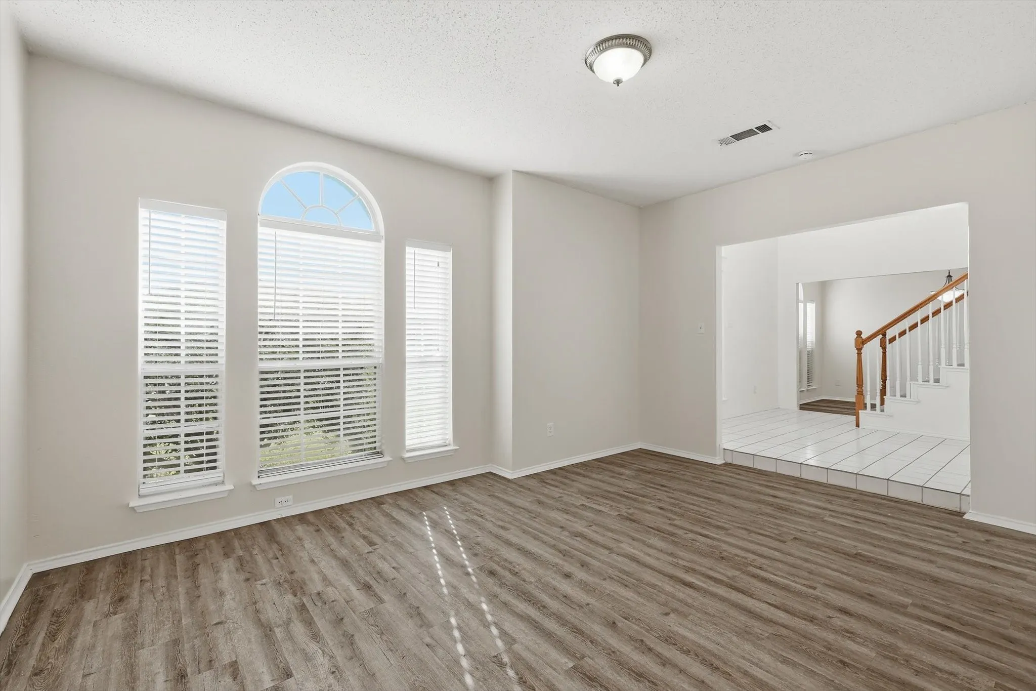 Spare room with wood finished floors and a textured ceiling