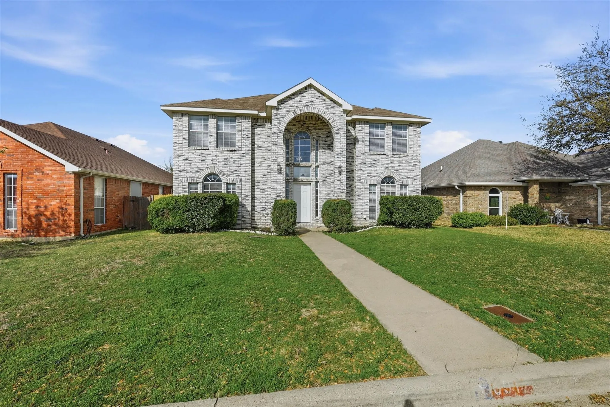 View of front of house featuring brick siding and a front lawn