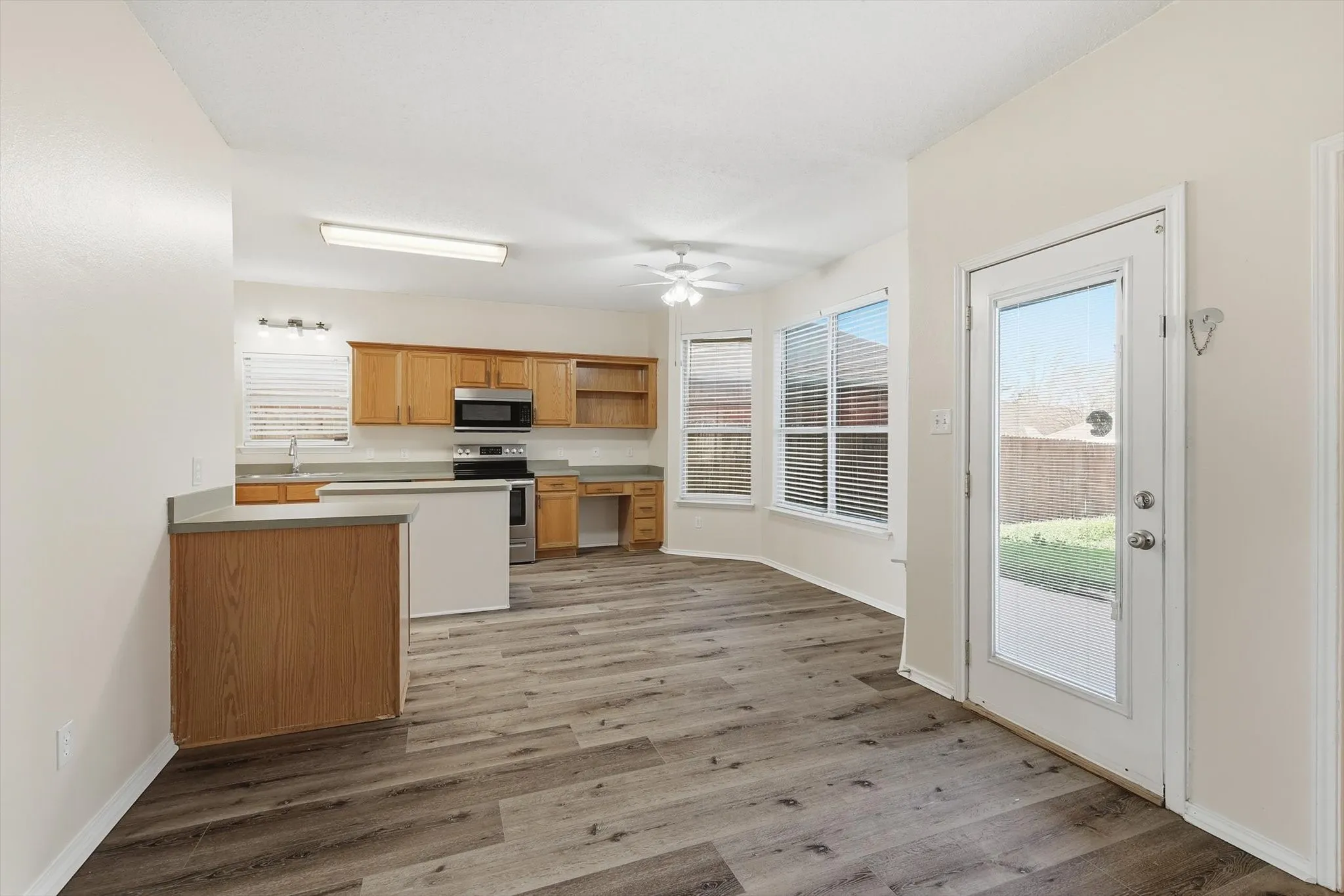 Kitchen featuring open shelves, stainless steel appliances, dark wood-style floors, and ceiling fan