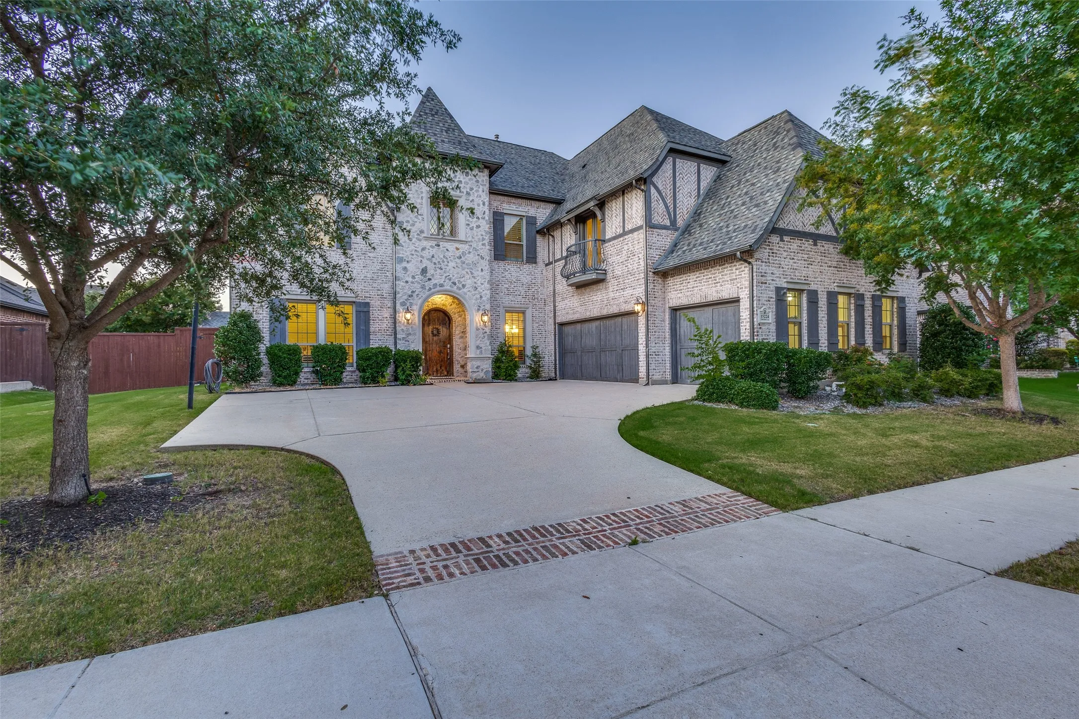 French country inspired stone elevation featuring J swing driveway, 3 car garage and Juliette balcony