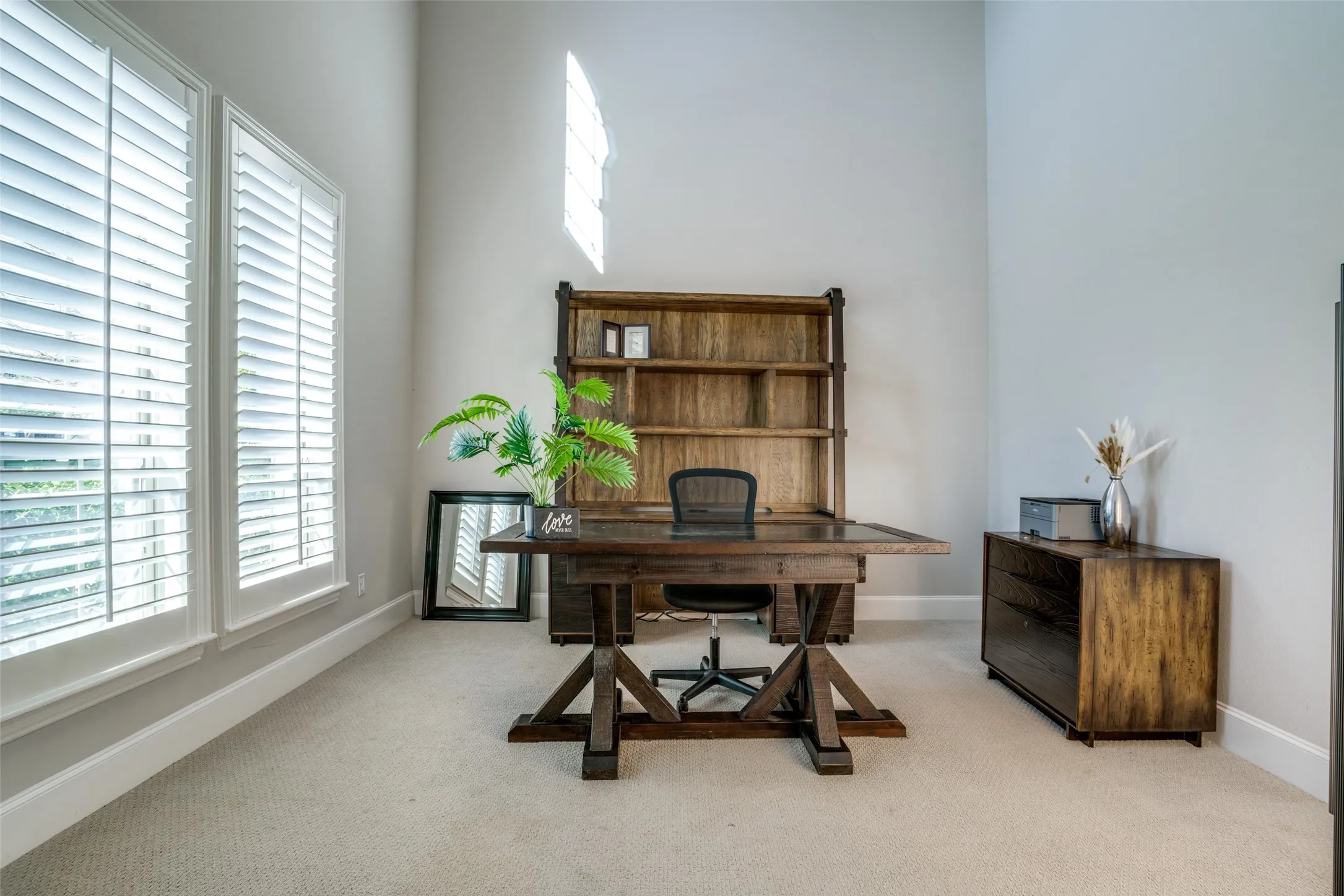 Office featuring soaring 2 story ceiling and double doors