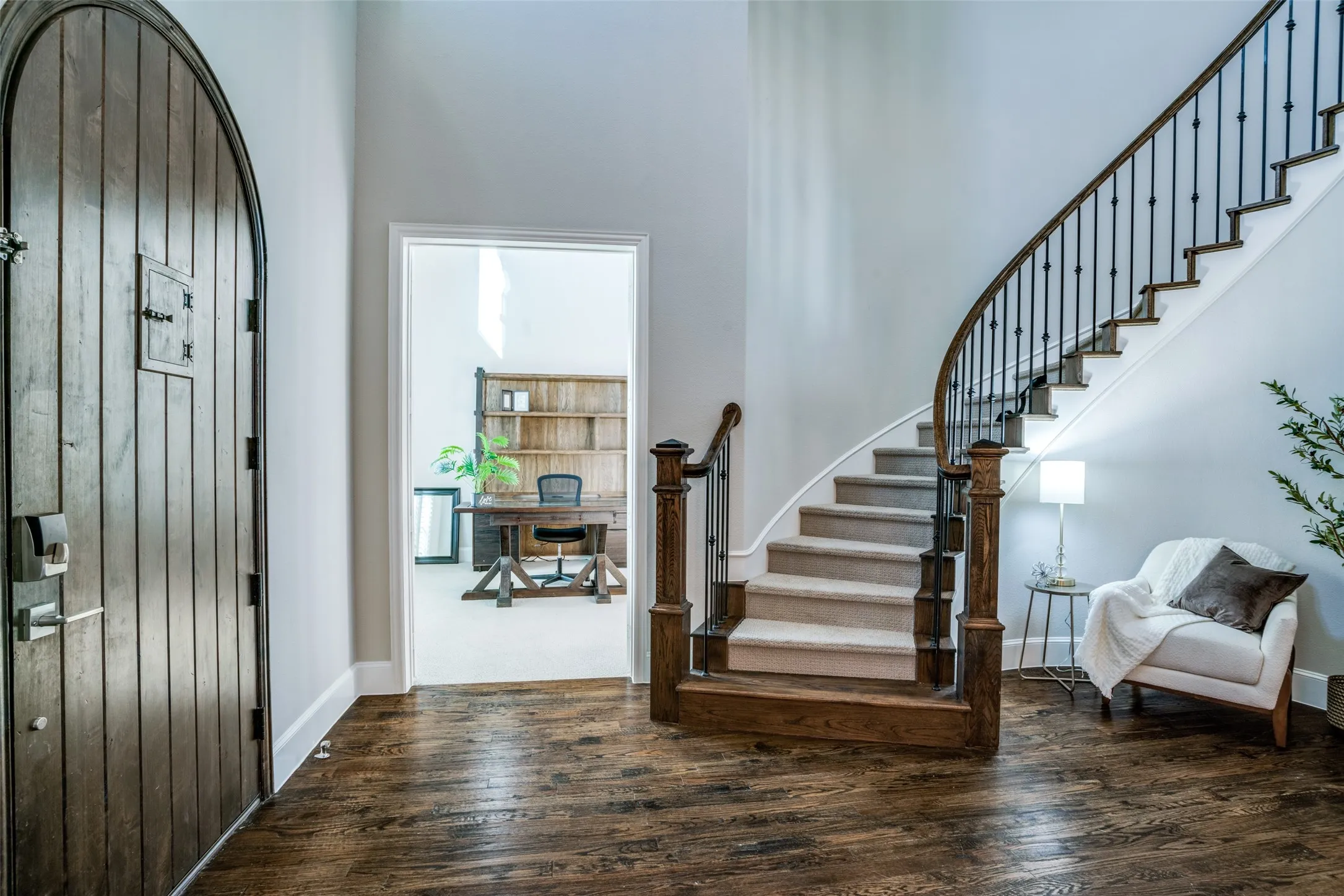 Foyer with curved stairway, a high ceiling, and wood flooring