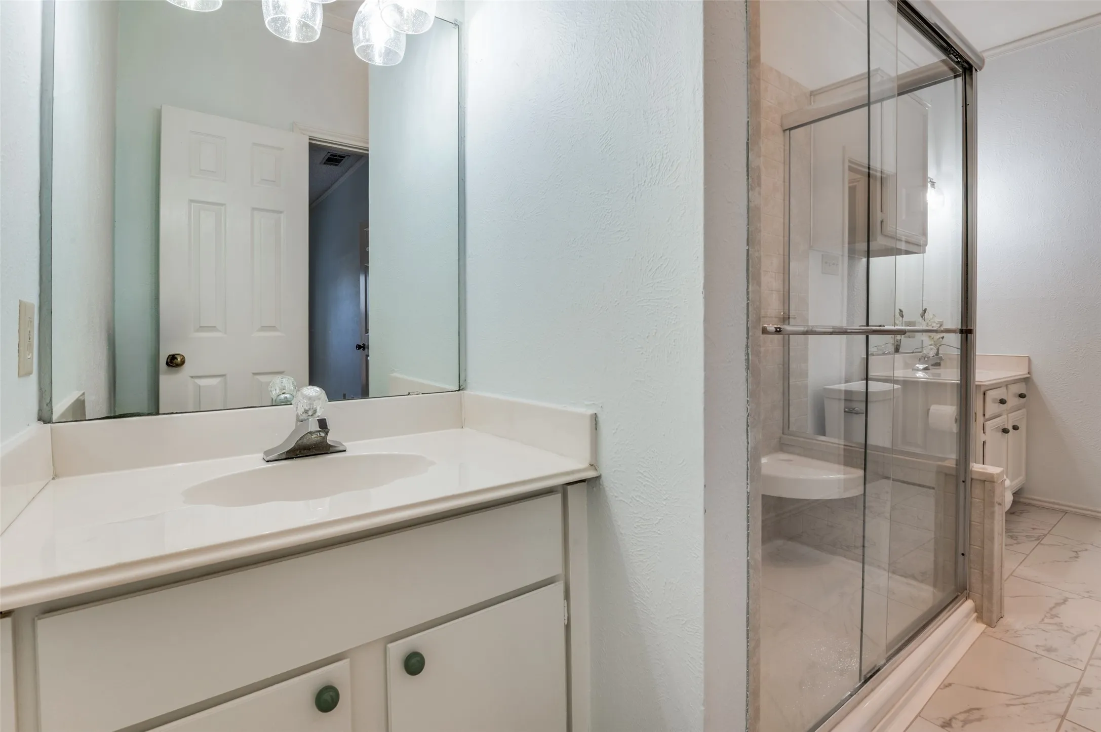 Separate vanities with spacious shower in between.