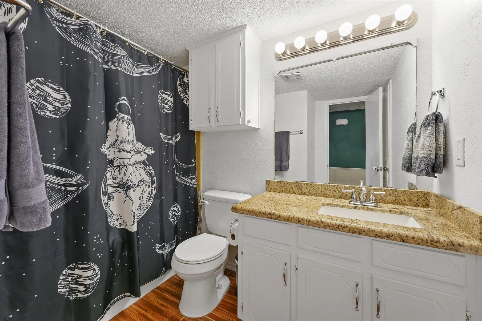 bathroom with granite countertop, ample storage, and clean, functional layout.