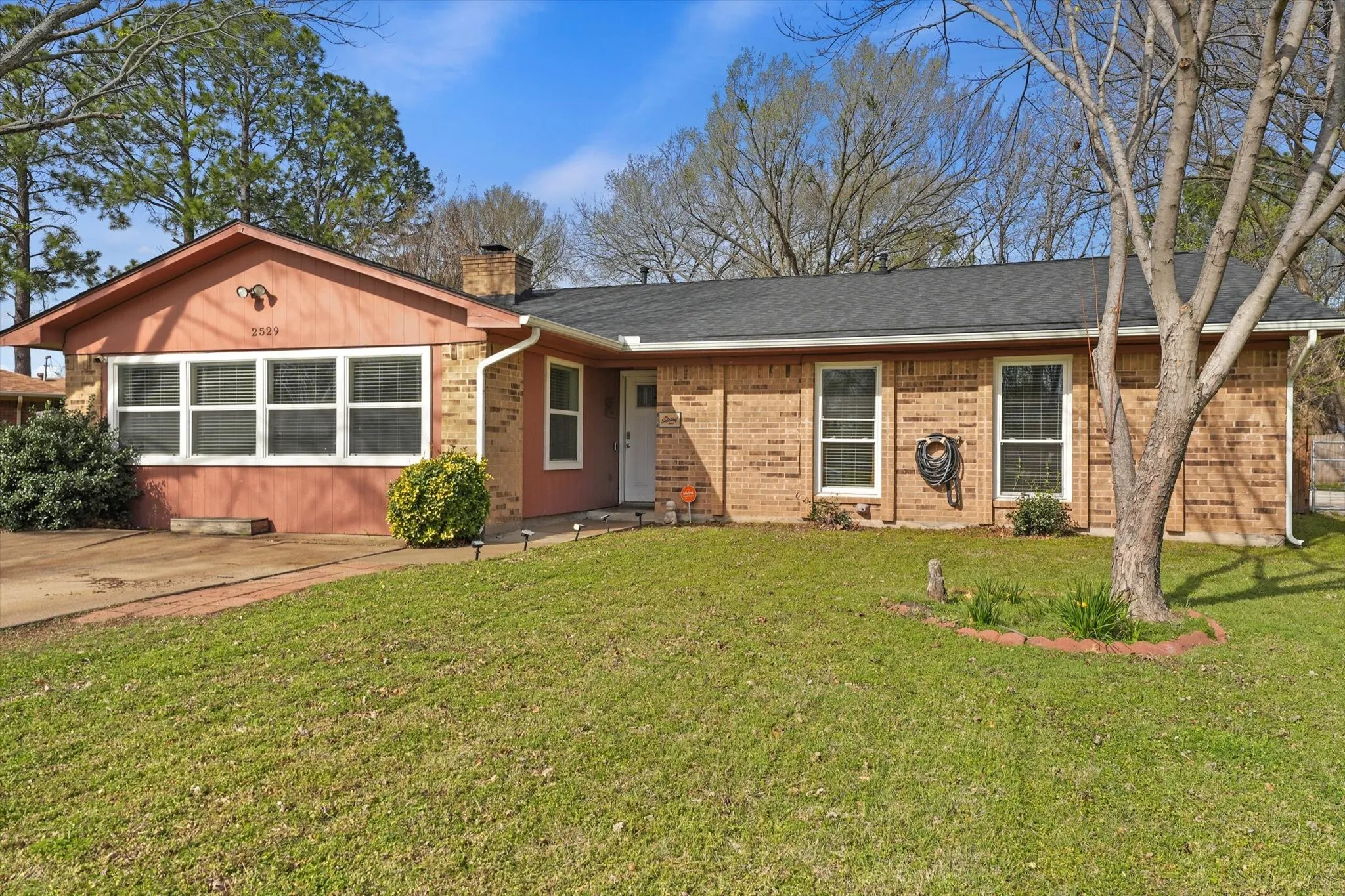 Spacious front yard with shade trees and classic Denton curb appeal—ideal for buyers searching established neighborhoods over new construction.