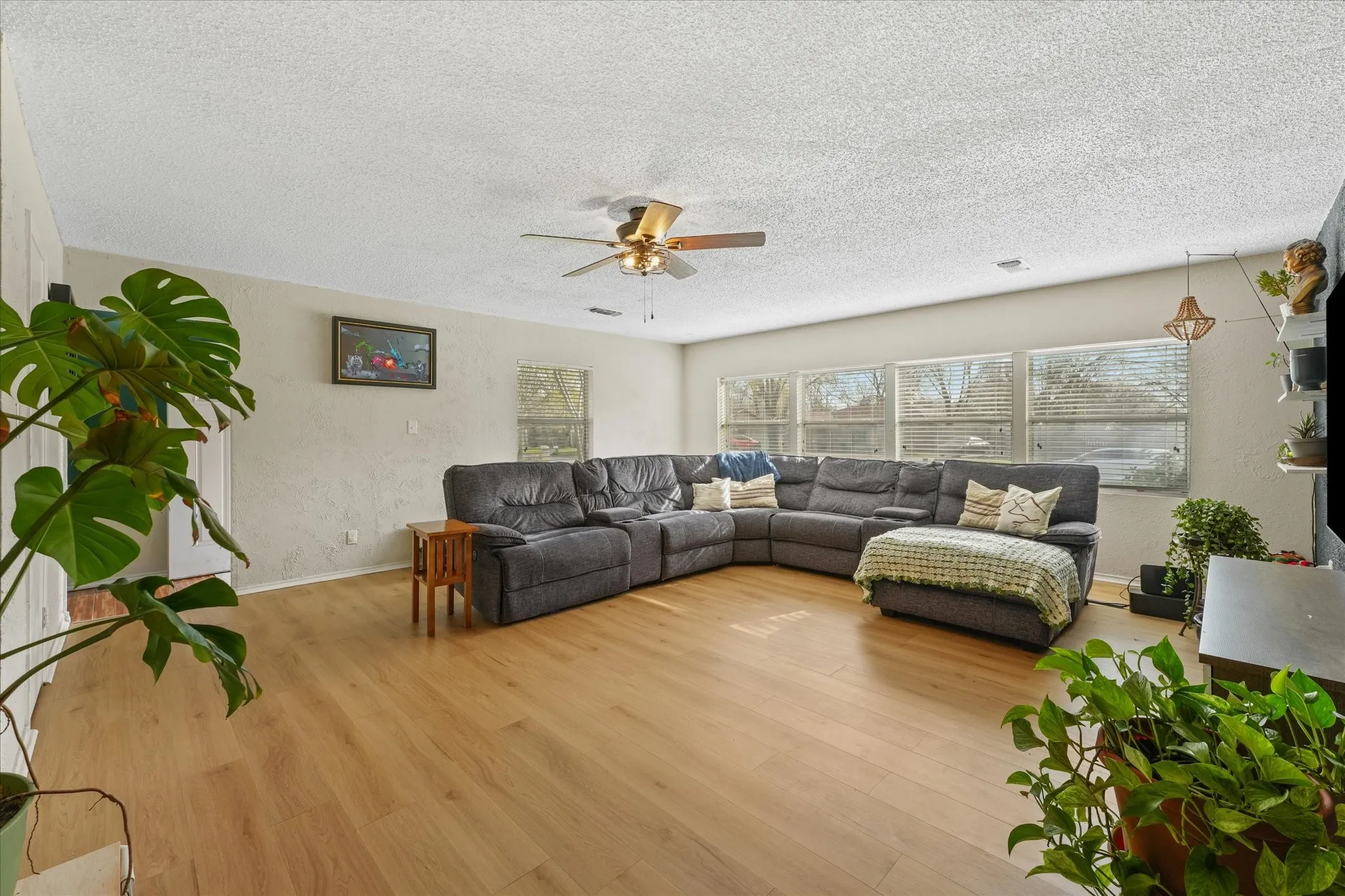 Bright living room with large windows and updated flooring—move-in ready and designed for everyday comfort.