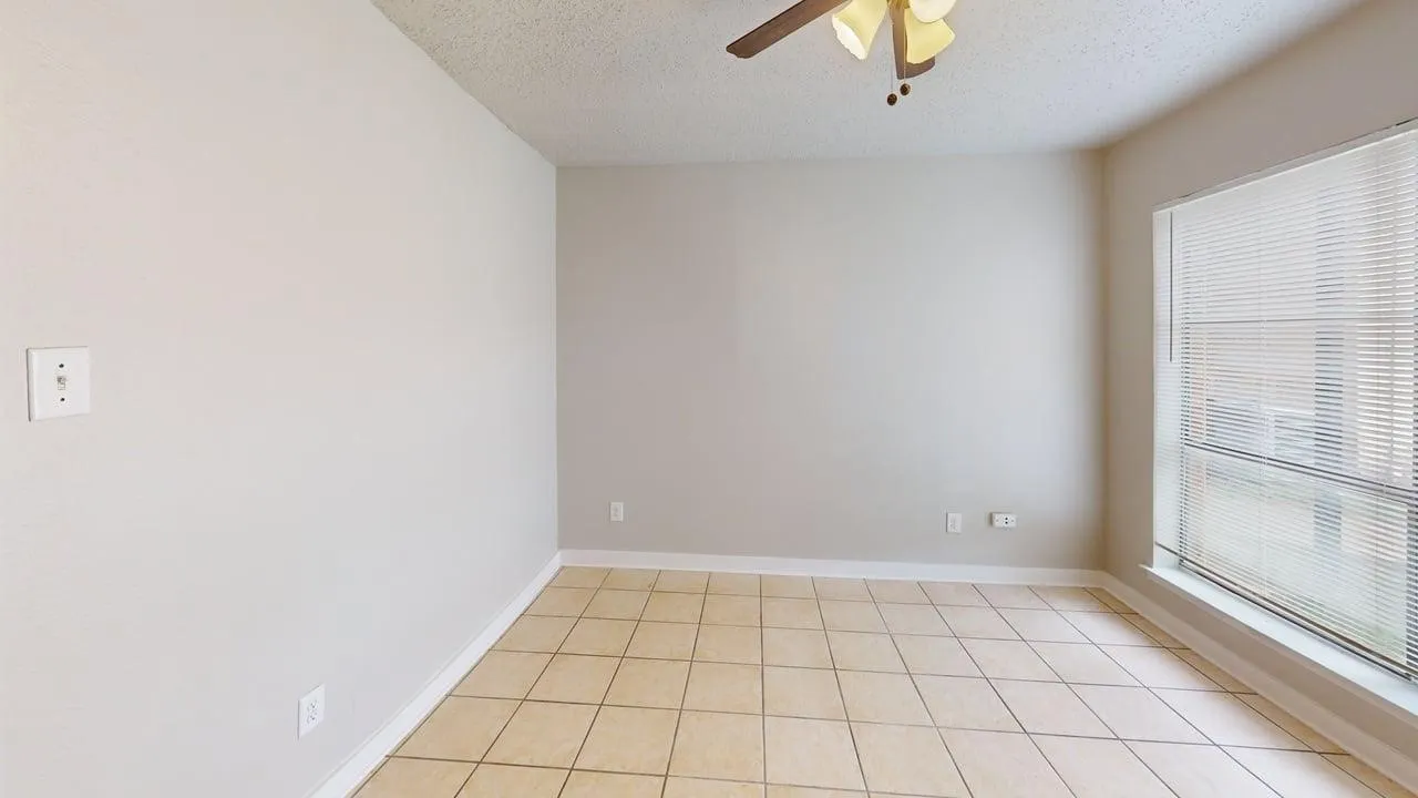 Unfurnished room featuring a ceiling fan, a textured ceiling, and light tile patterned floors