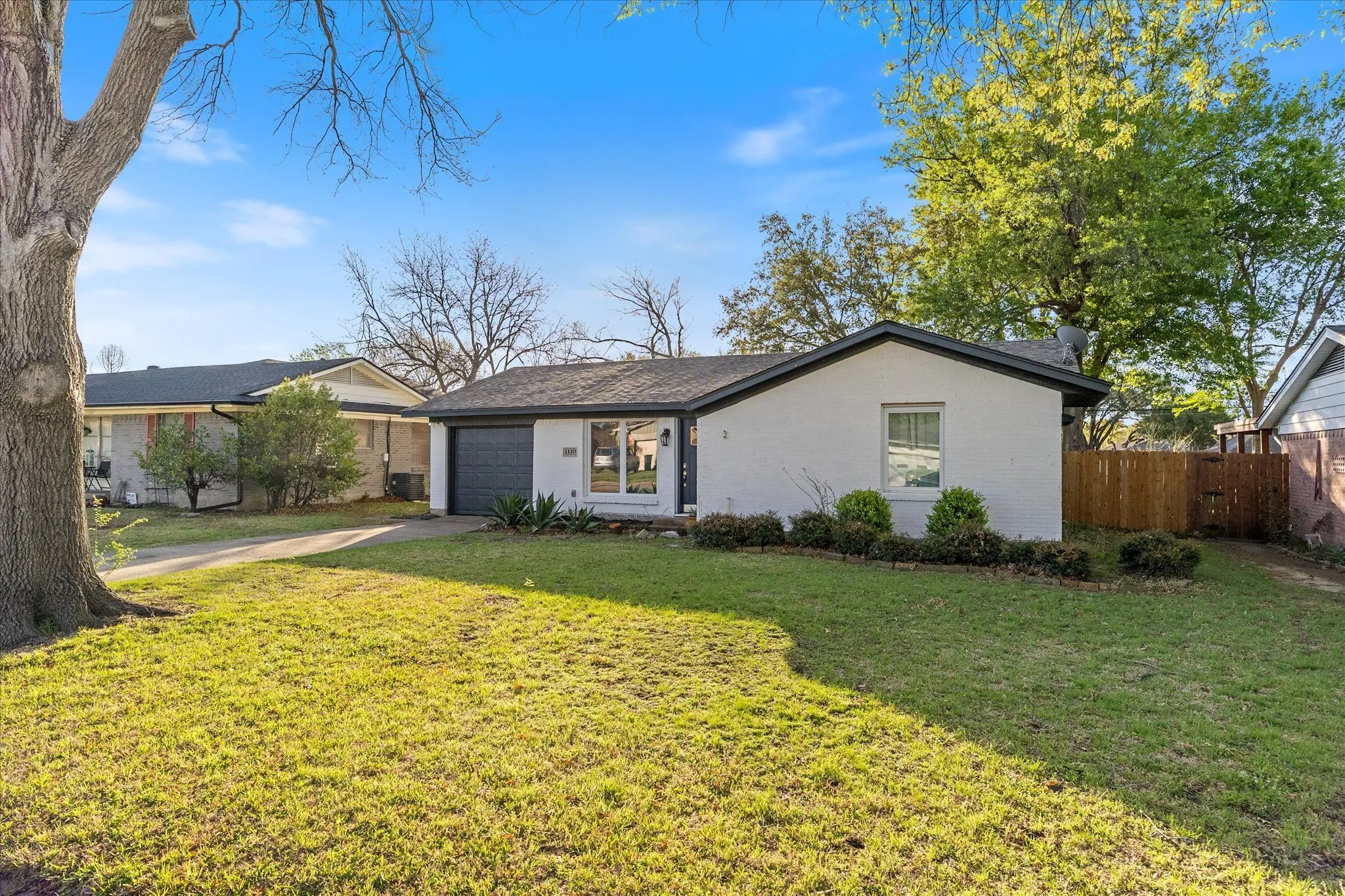 Mid-century modern home featuring brick siding, driveway, and a garage