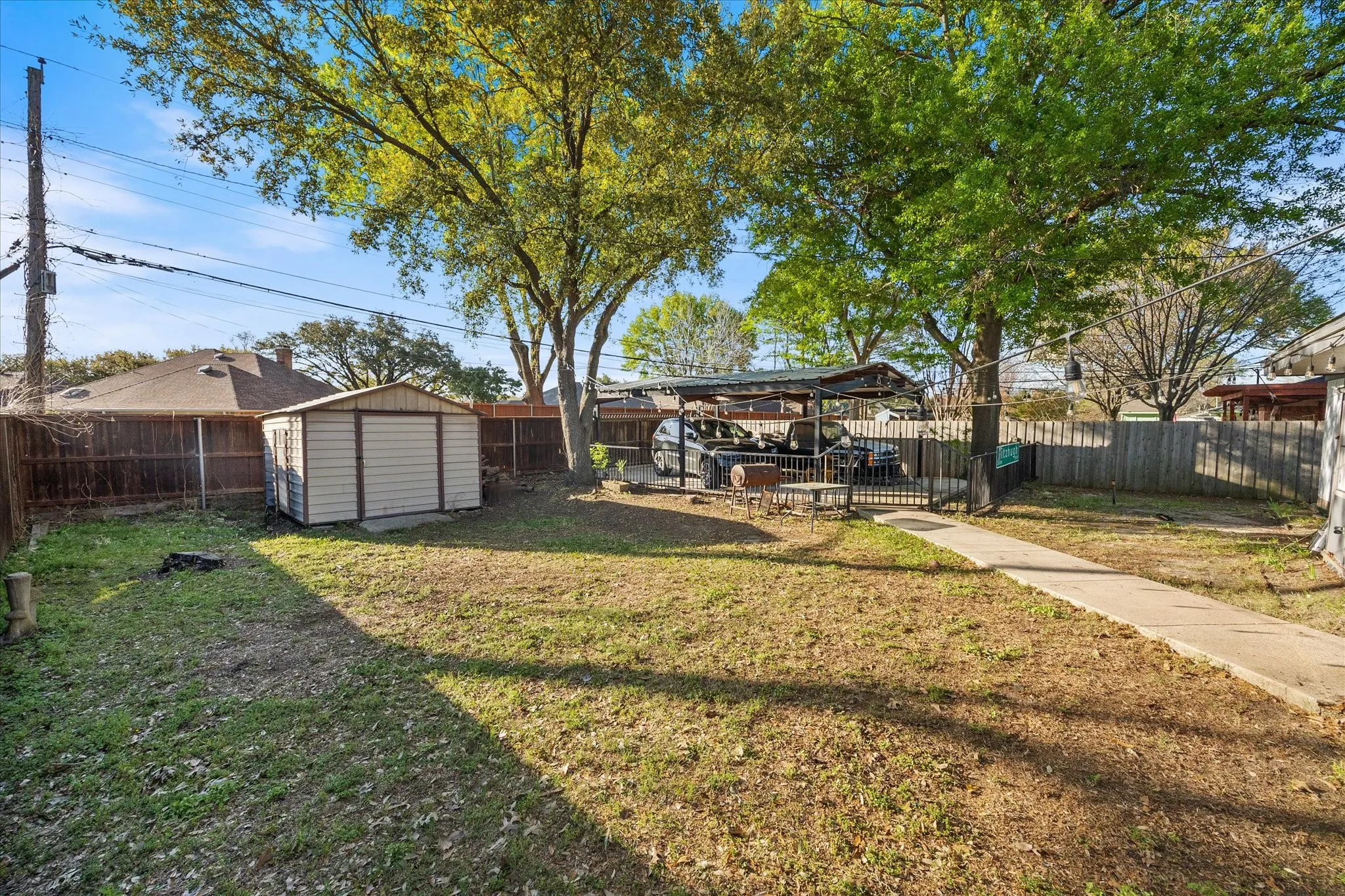 Fenced backyard featuring a storage shed
