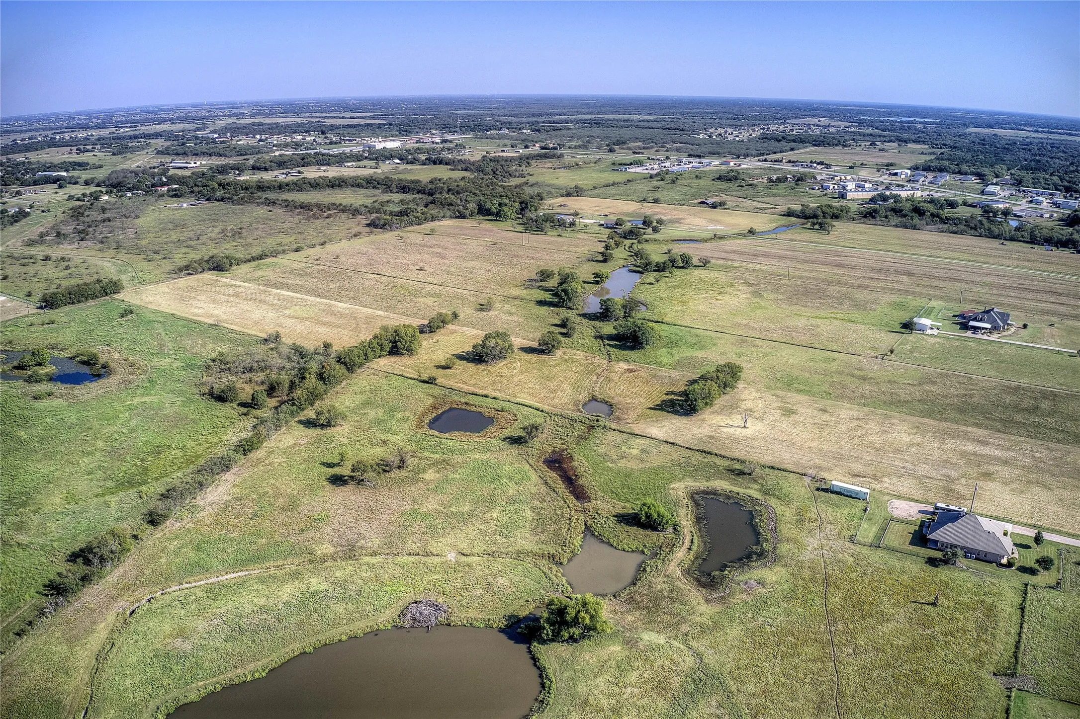 Aerial view of property and surrounding area featuring rural landscape and a large body of water