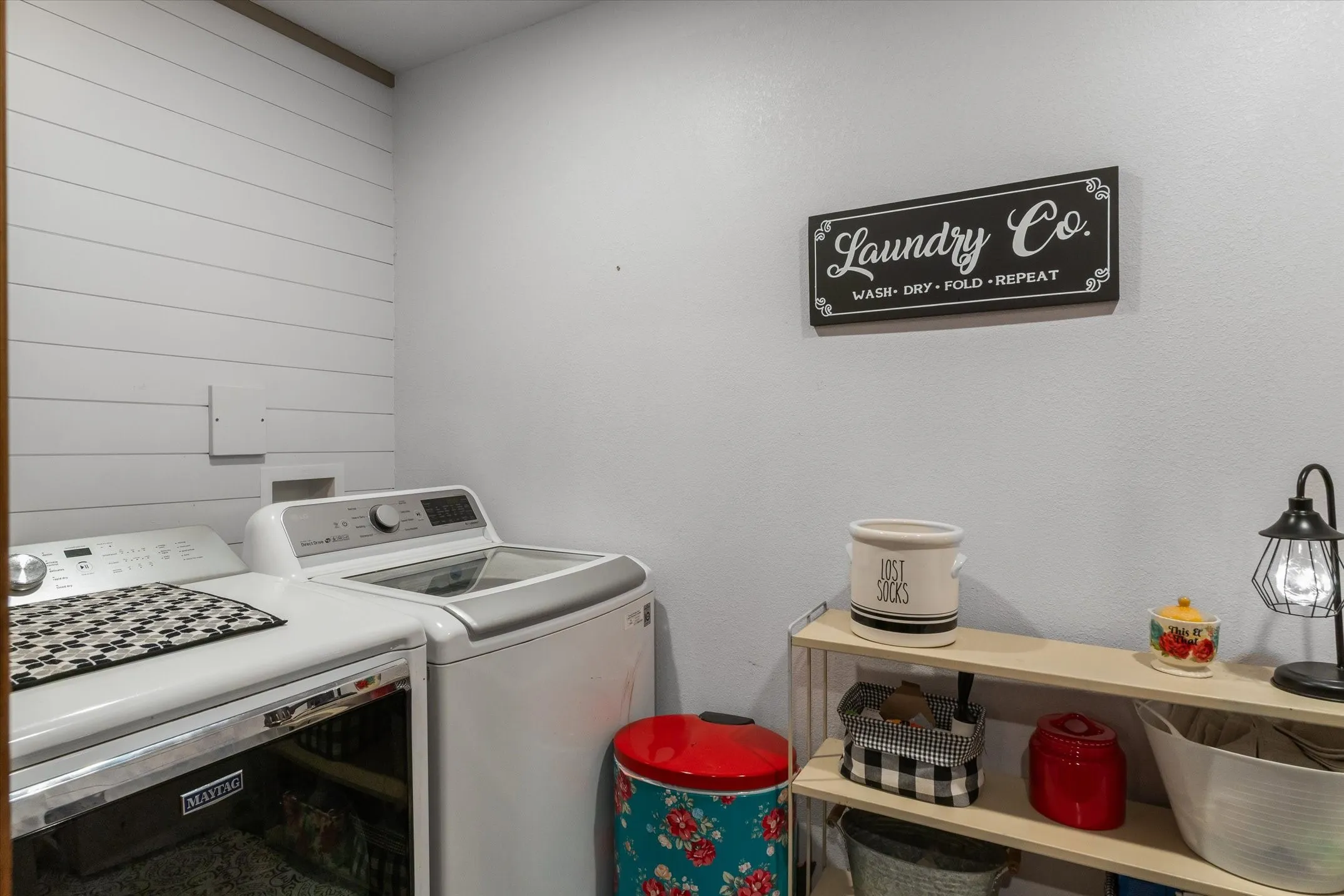 Laundry room with washing machine and dryer and wooden walls