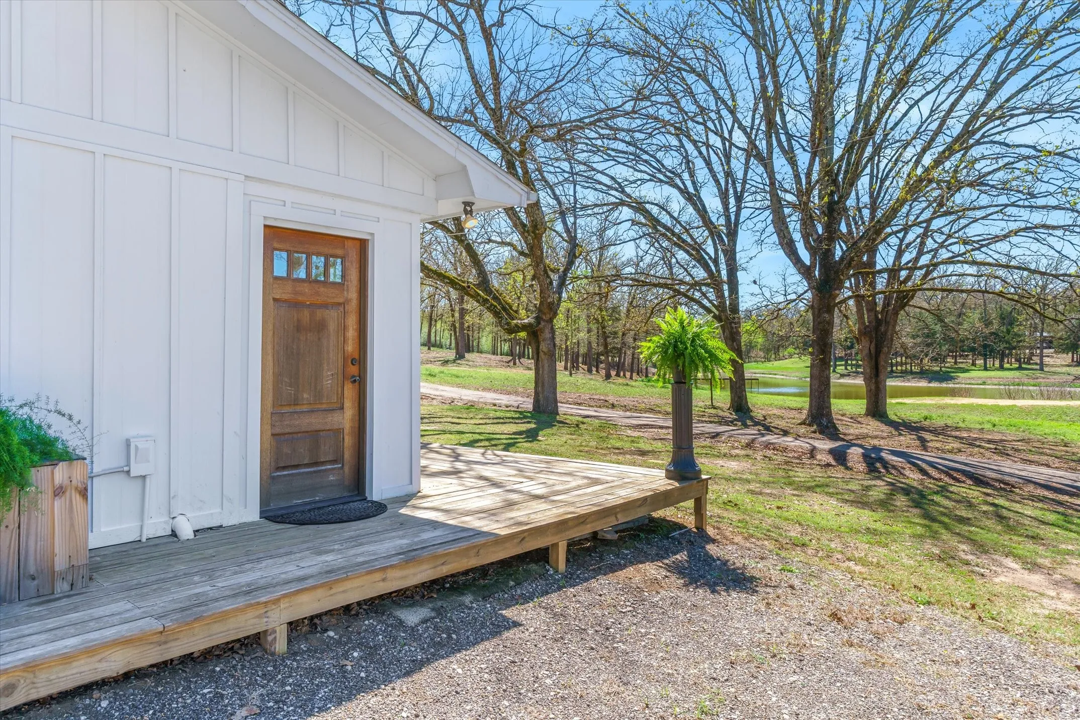 Doorway to property with board and batten siding and a wooden deck