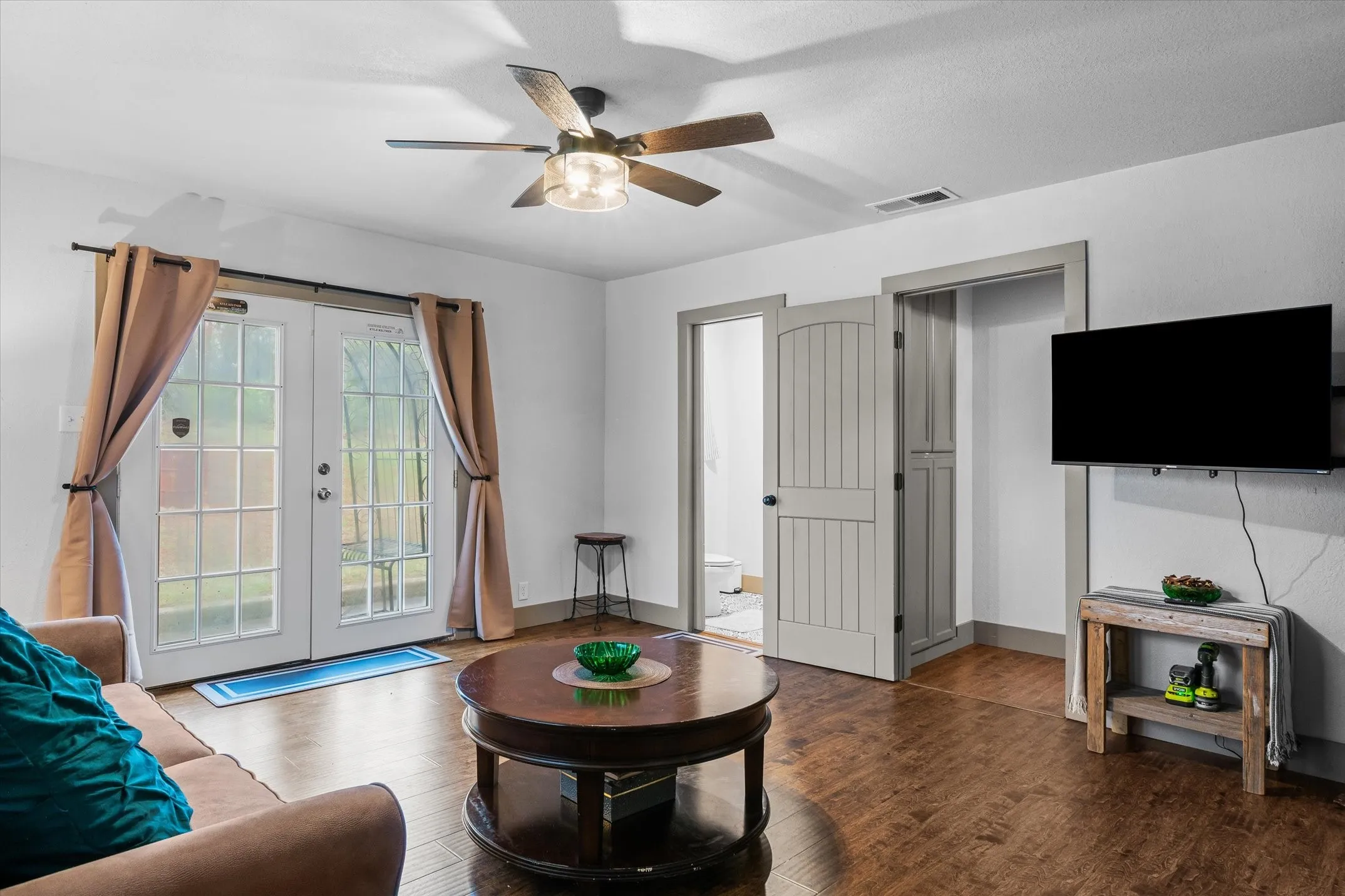 Bedroom featuring french doors, wood finished floors, and ceiling fan