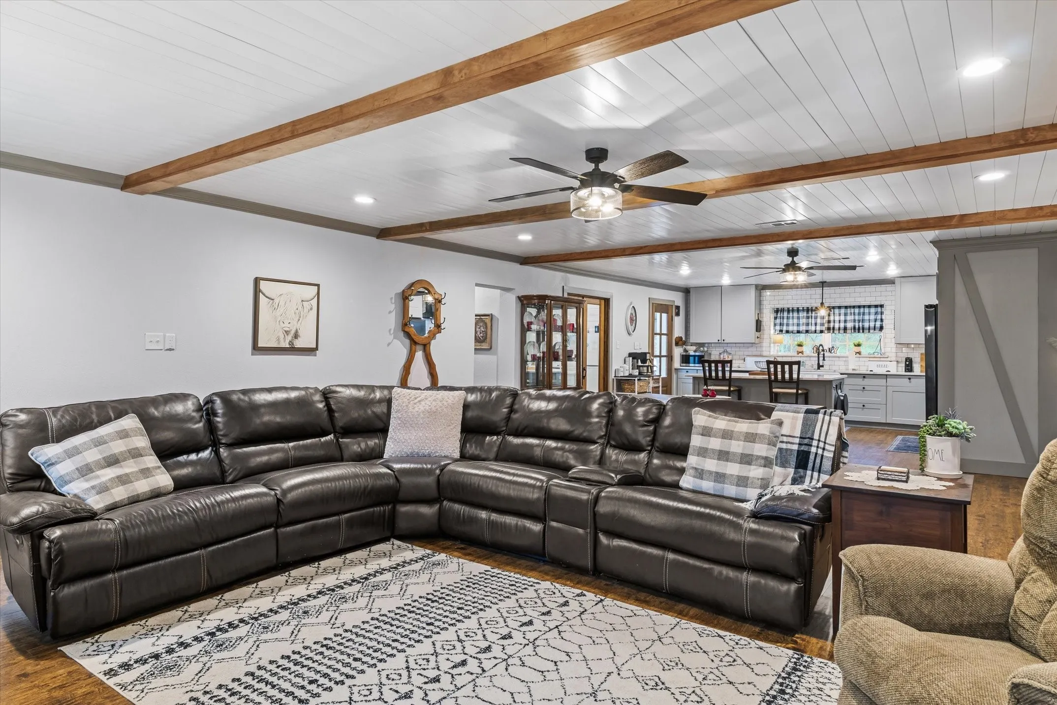 Living room with beam ceiling, recessed lighting, and dark wood-style floors