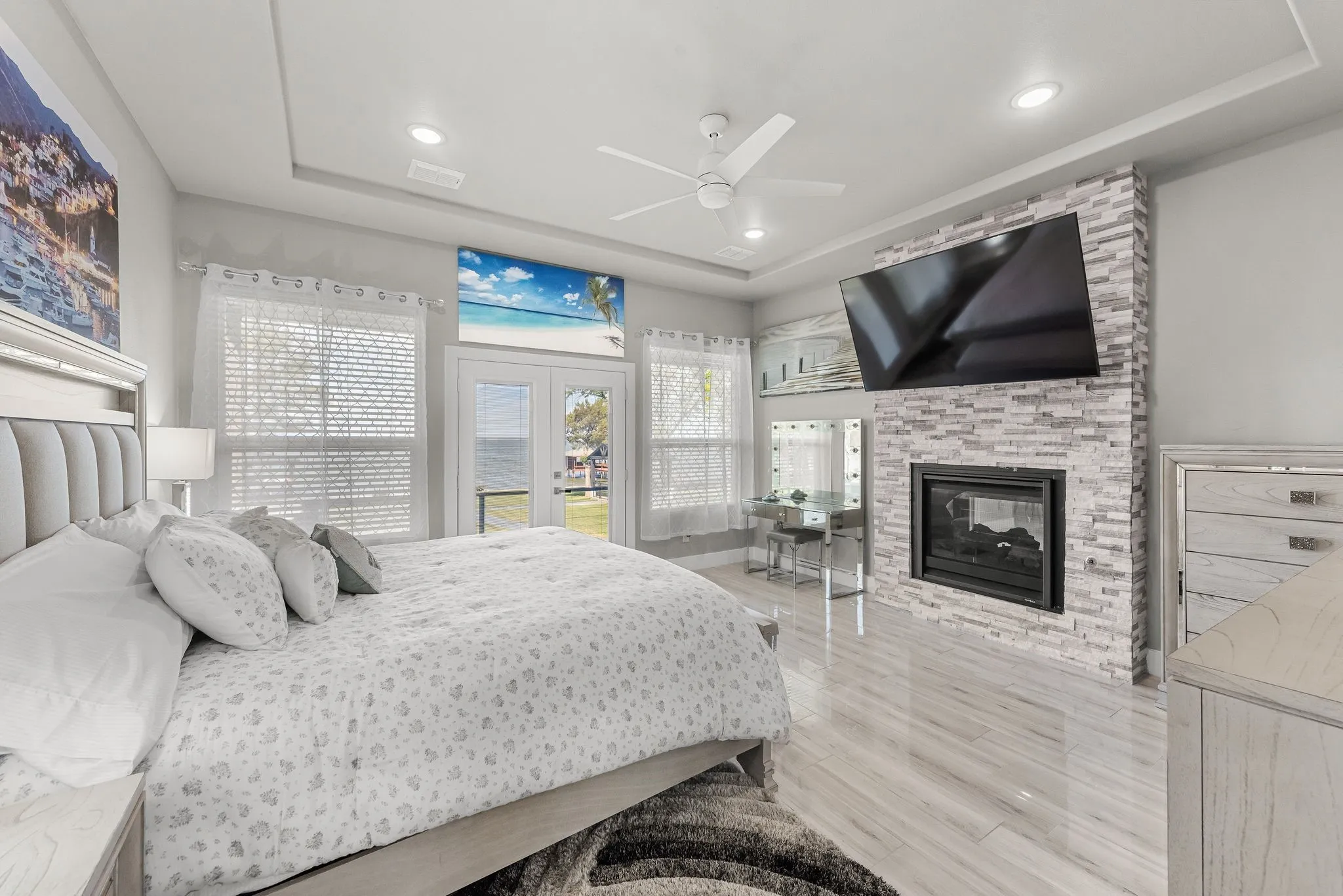Primary bedroom with fireplace, lake-inspired decor, and peaceful retreat-style design.