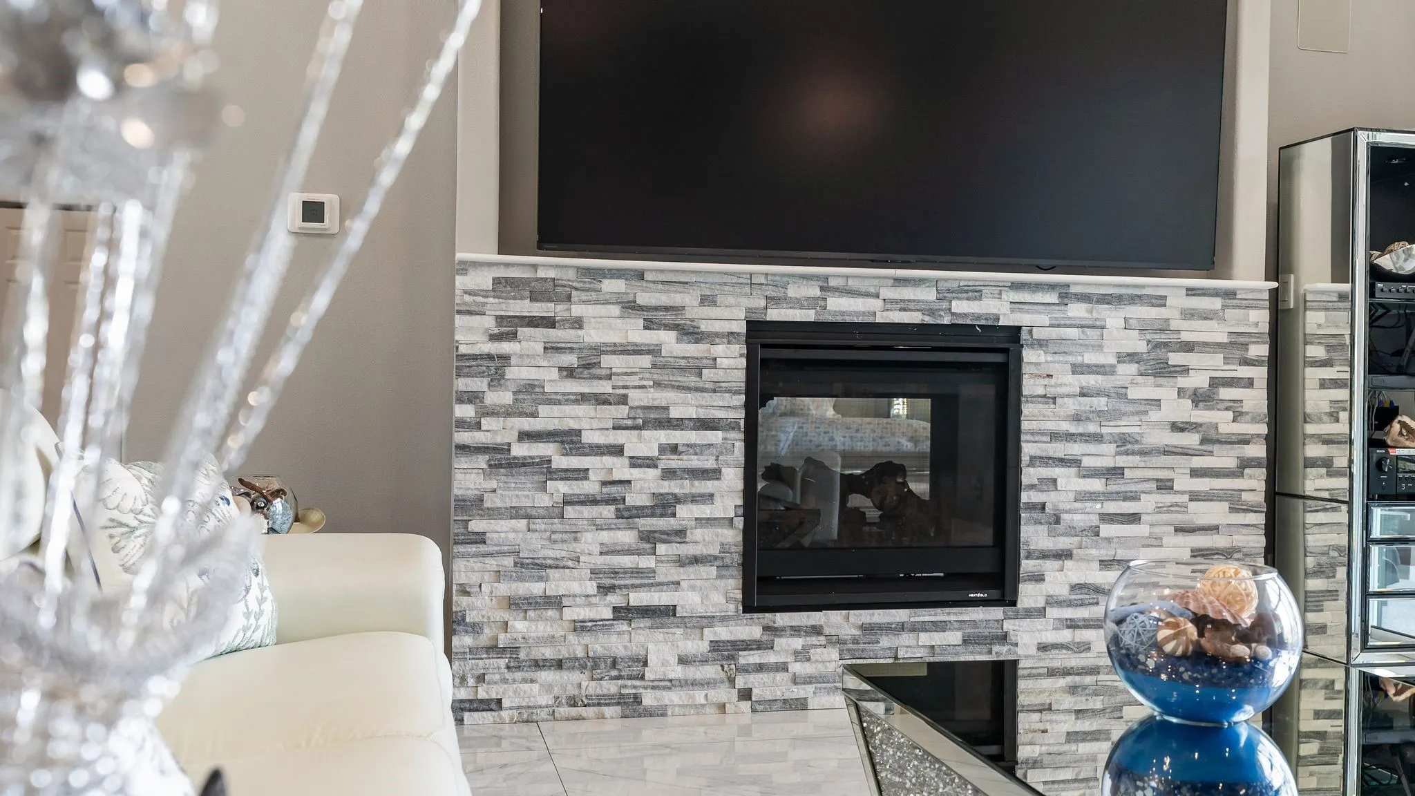 Gas fireplace detail with modern stone surround and cozy lake house ambiance.