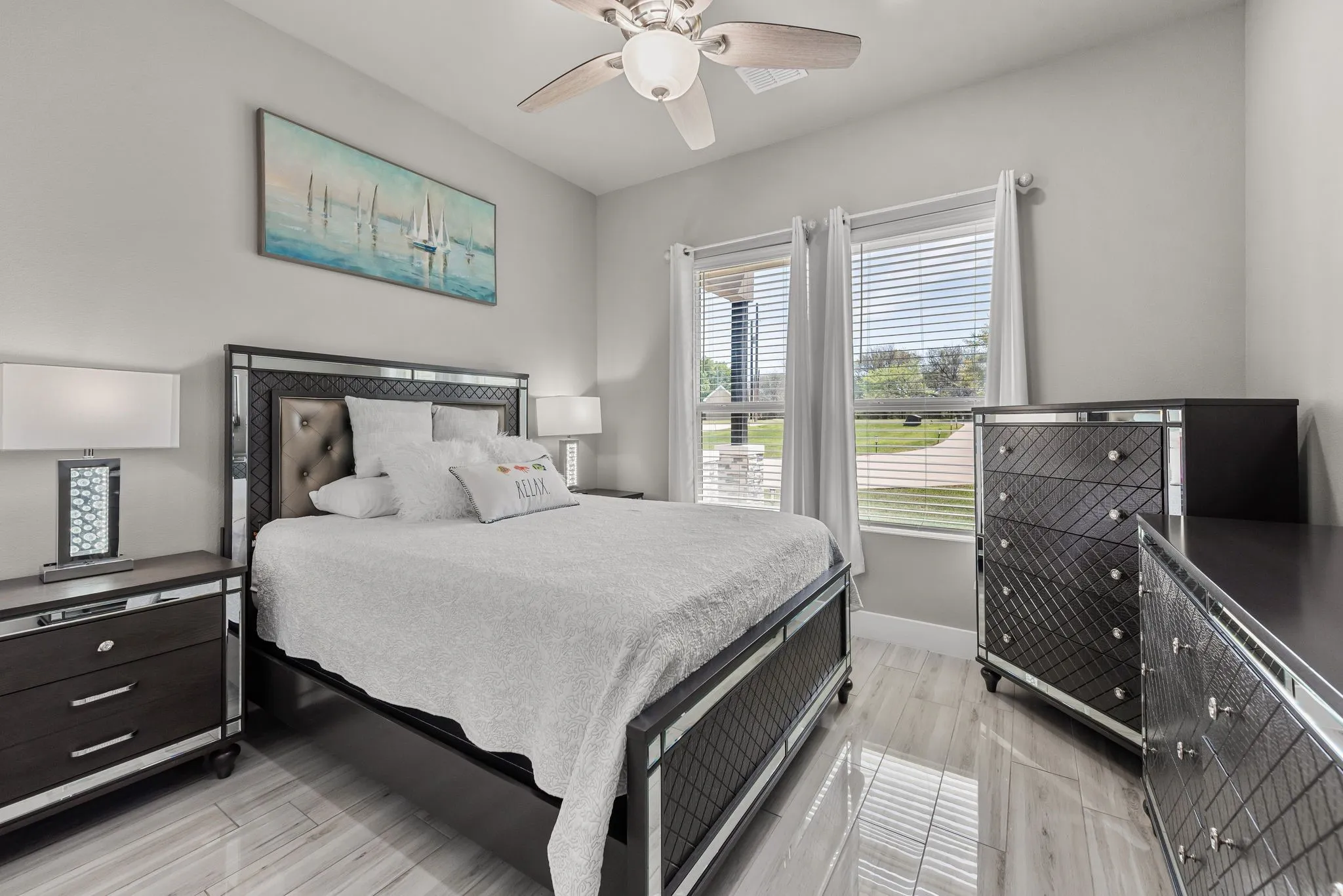 Guest bedroom with windows, ceiling fan, and flexible space for visitors or family.