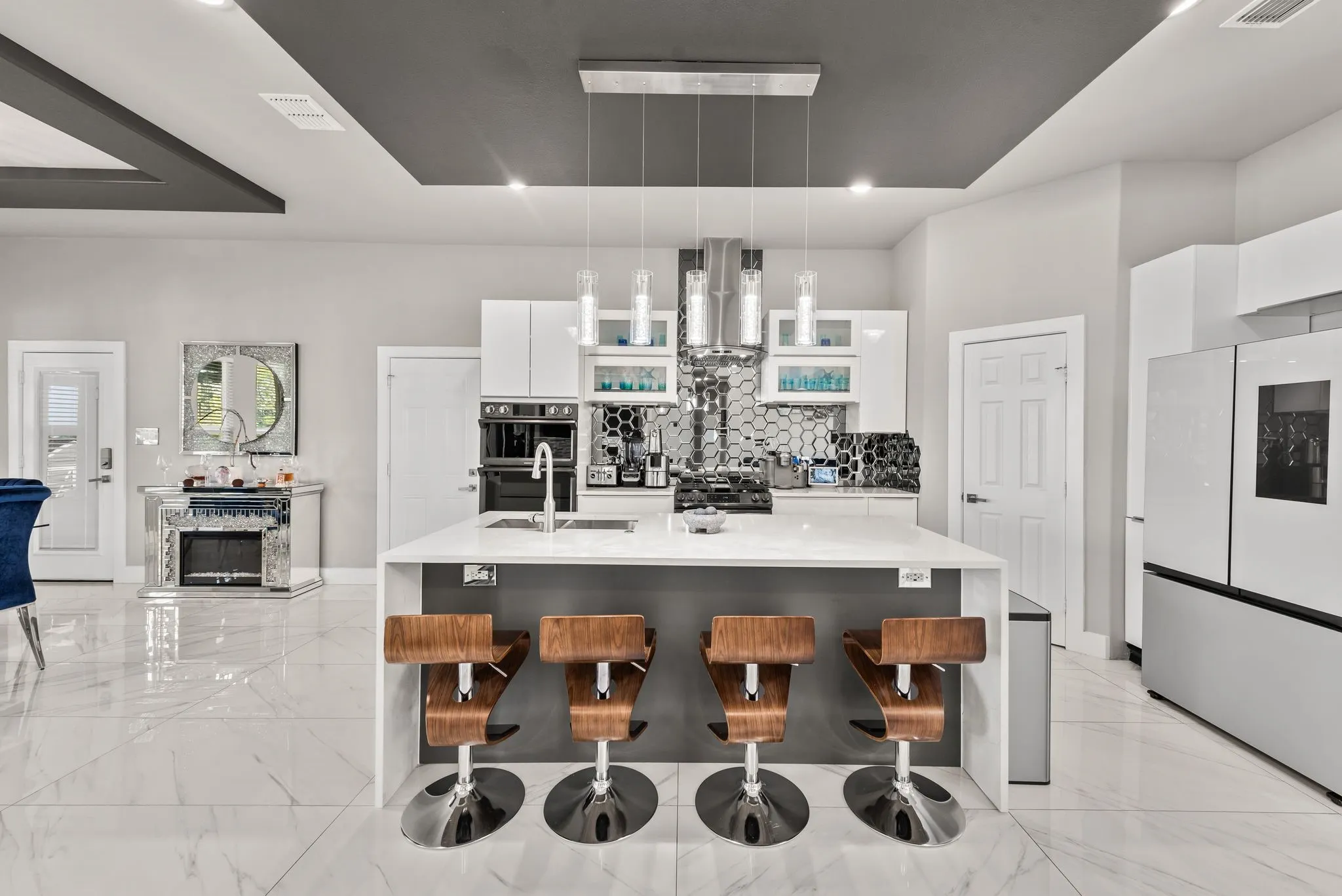 Modern kitchen with large island, bar seating, and open flow to dining and living spaces.