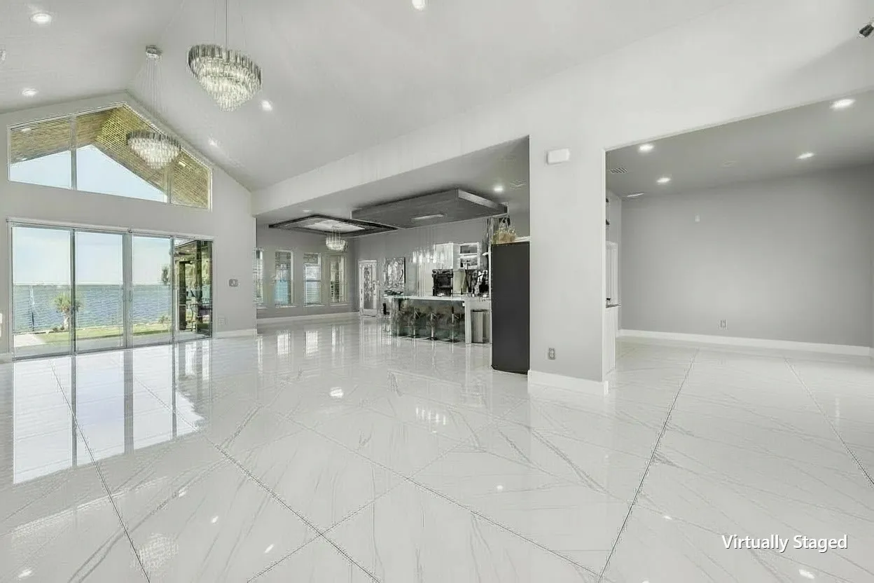 Expansive open living space with cathedral ceilings, glossy floors, and waterfront views. Digitally altered to remove furniture.