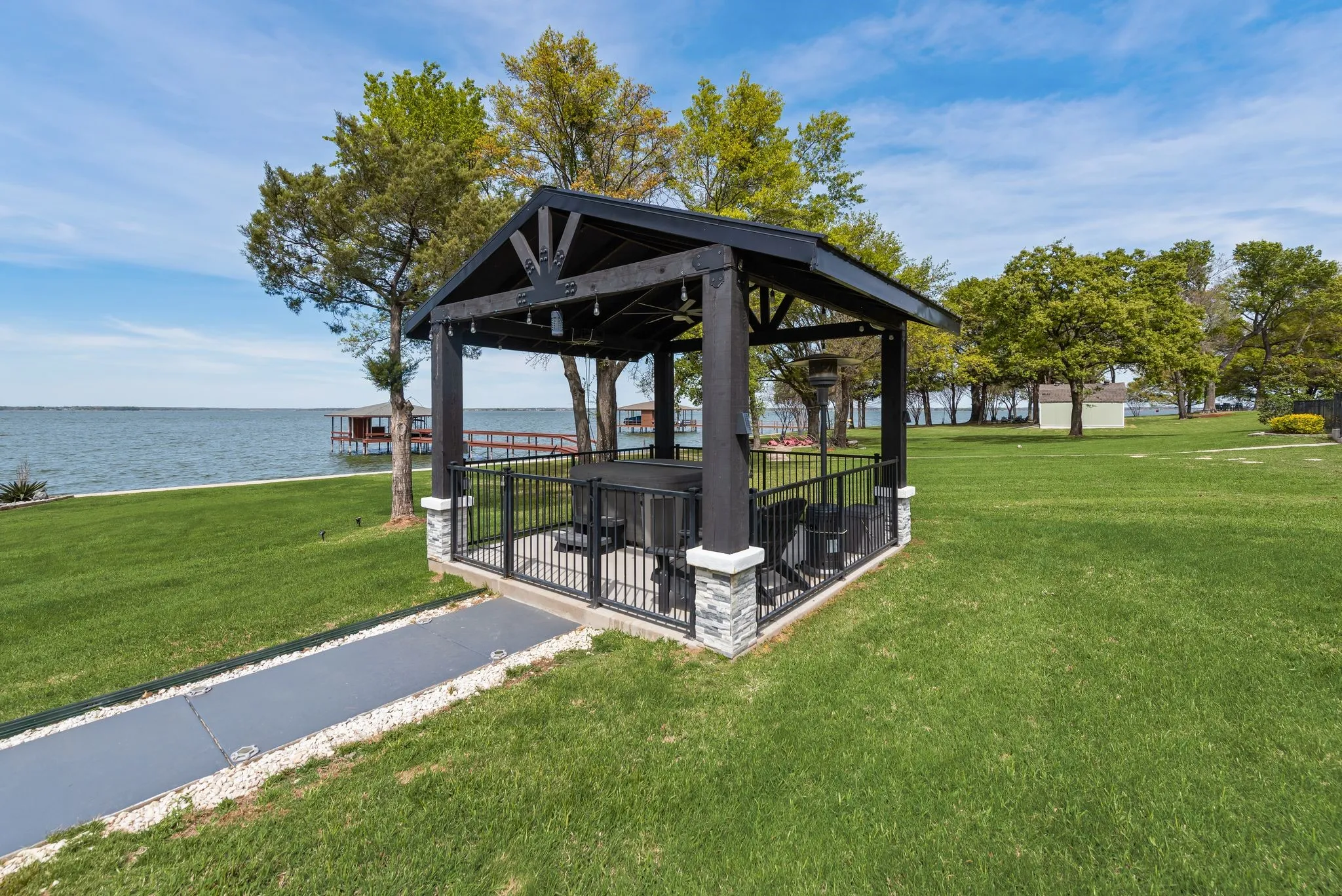 Lakeside pergola area with open lawn and peaceful waterfront views.