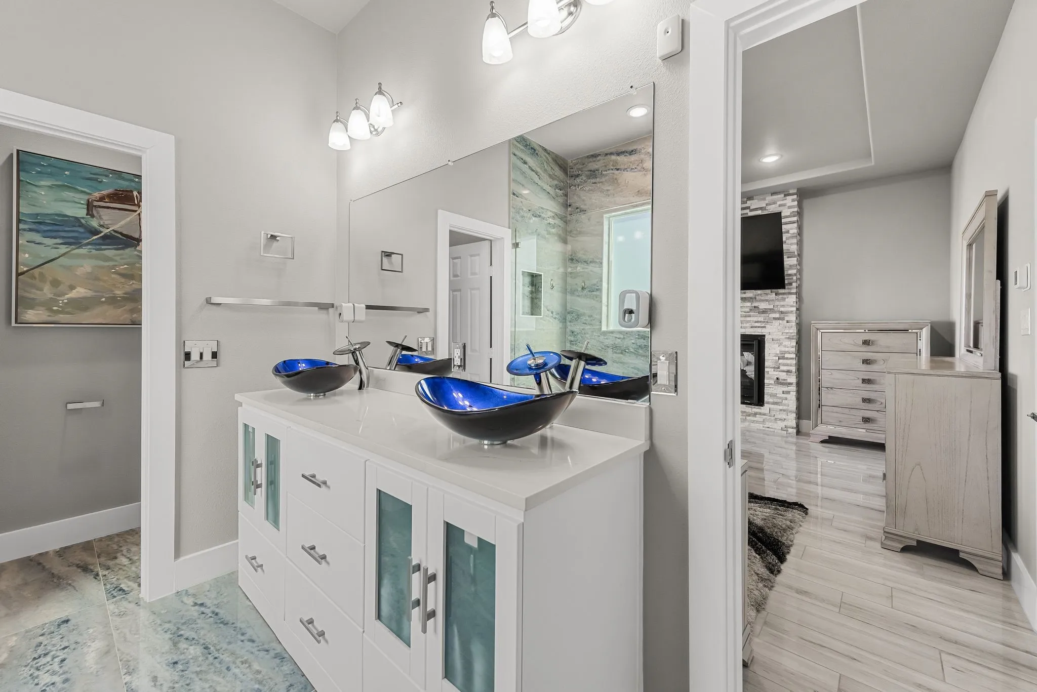 Bathroom vanity with blue vessel sink and stylish modern finishes.