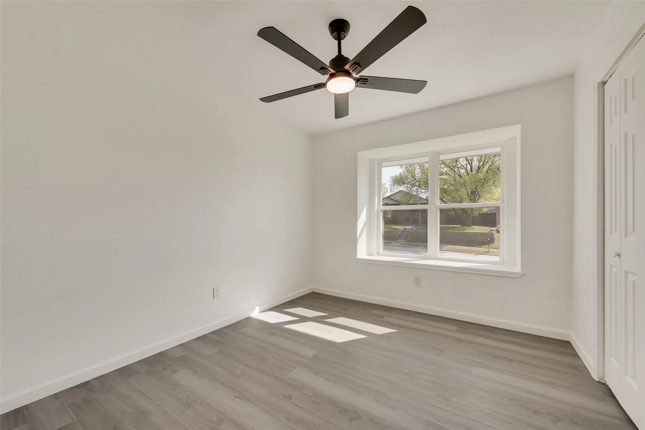 Unfurnished bedroom featuring a closet, light wood-style flooring, and a ceiling fan