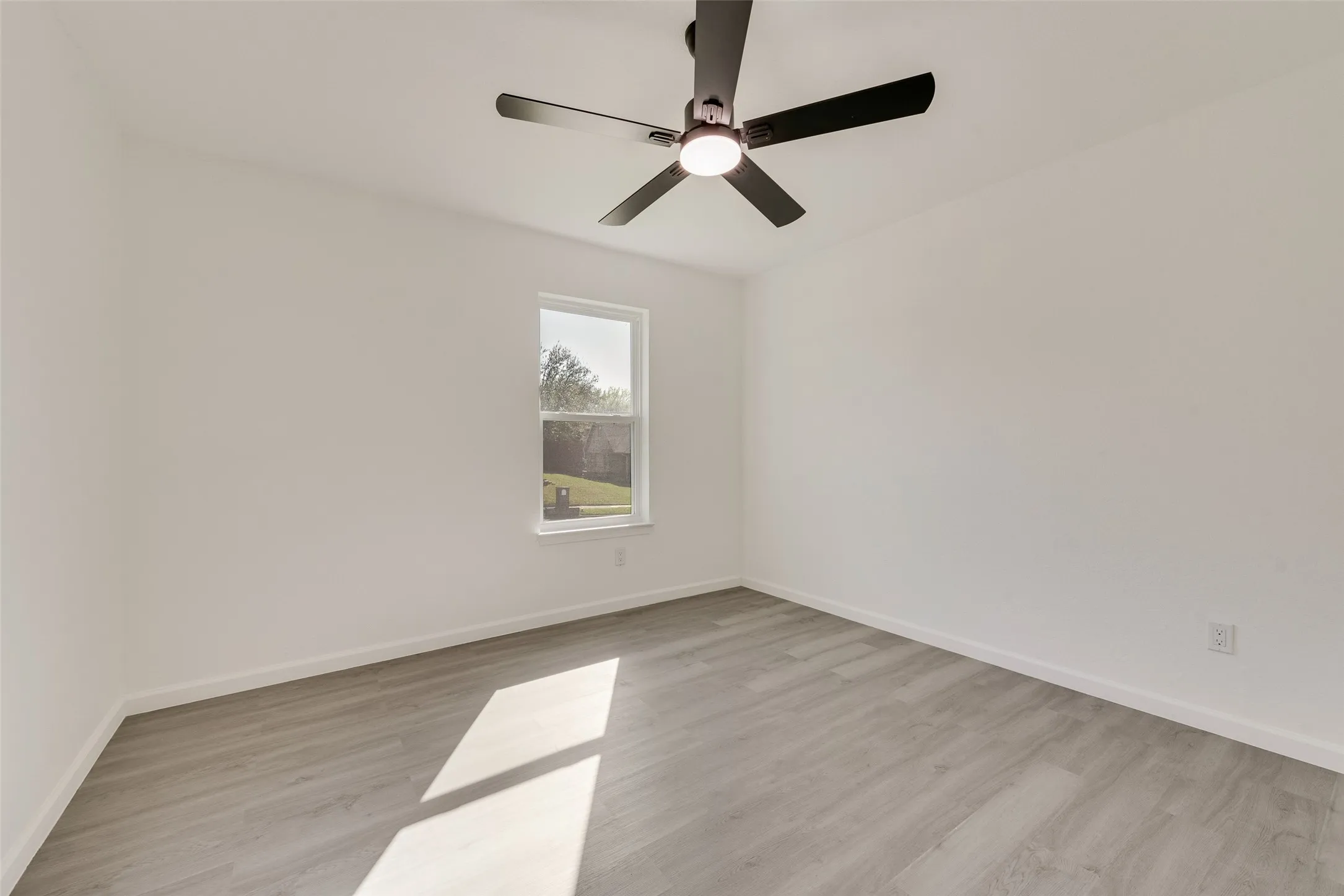 Spare room featuring light wood-style floors and a ceiling fan