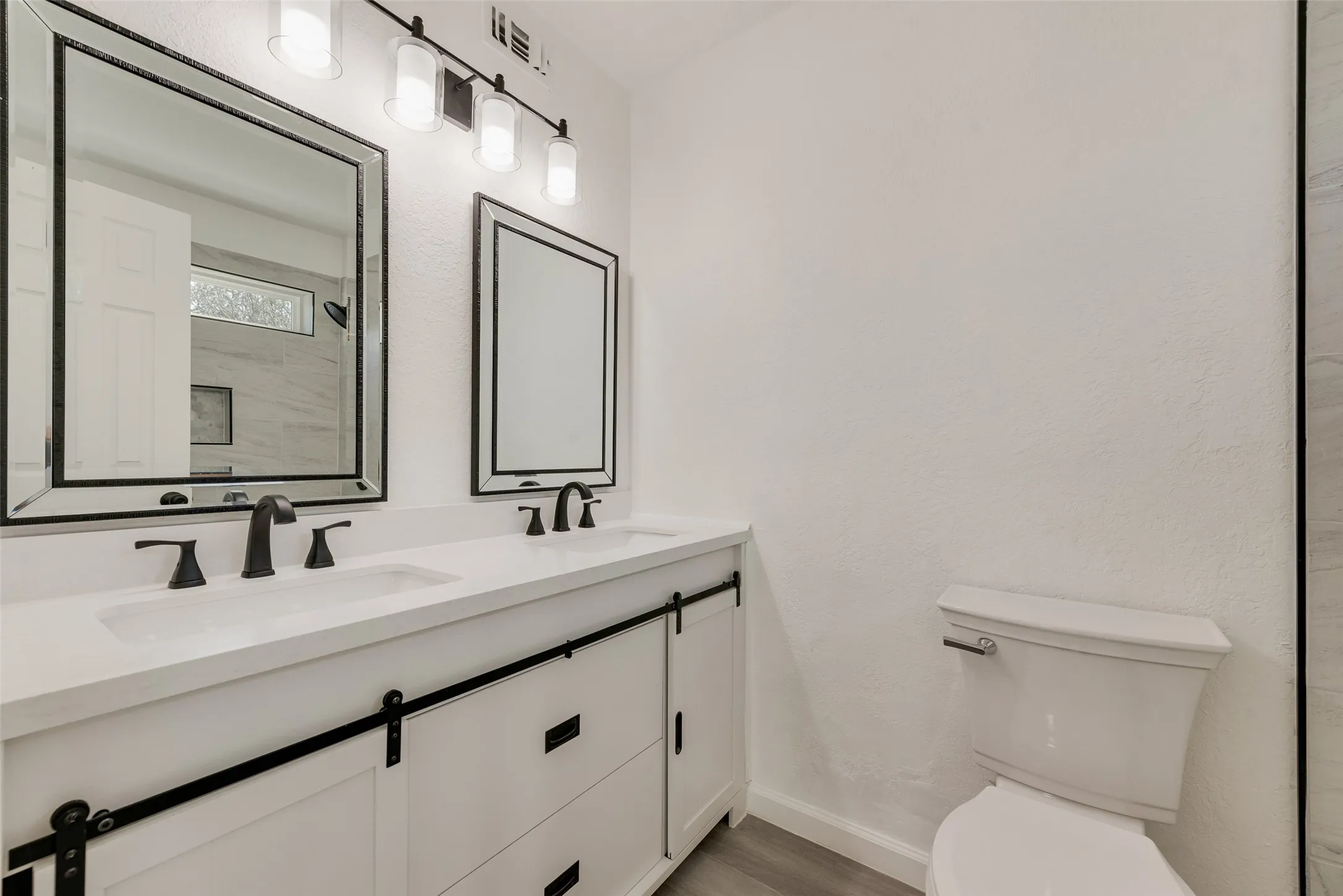 Bathroom featuring double vanity and light wood-style flooring